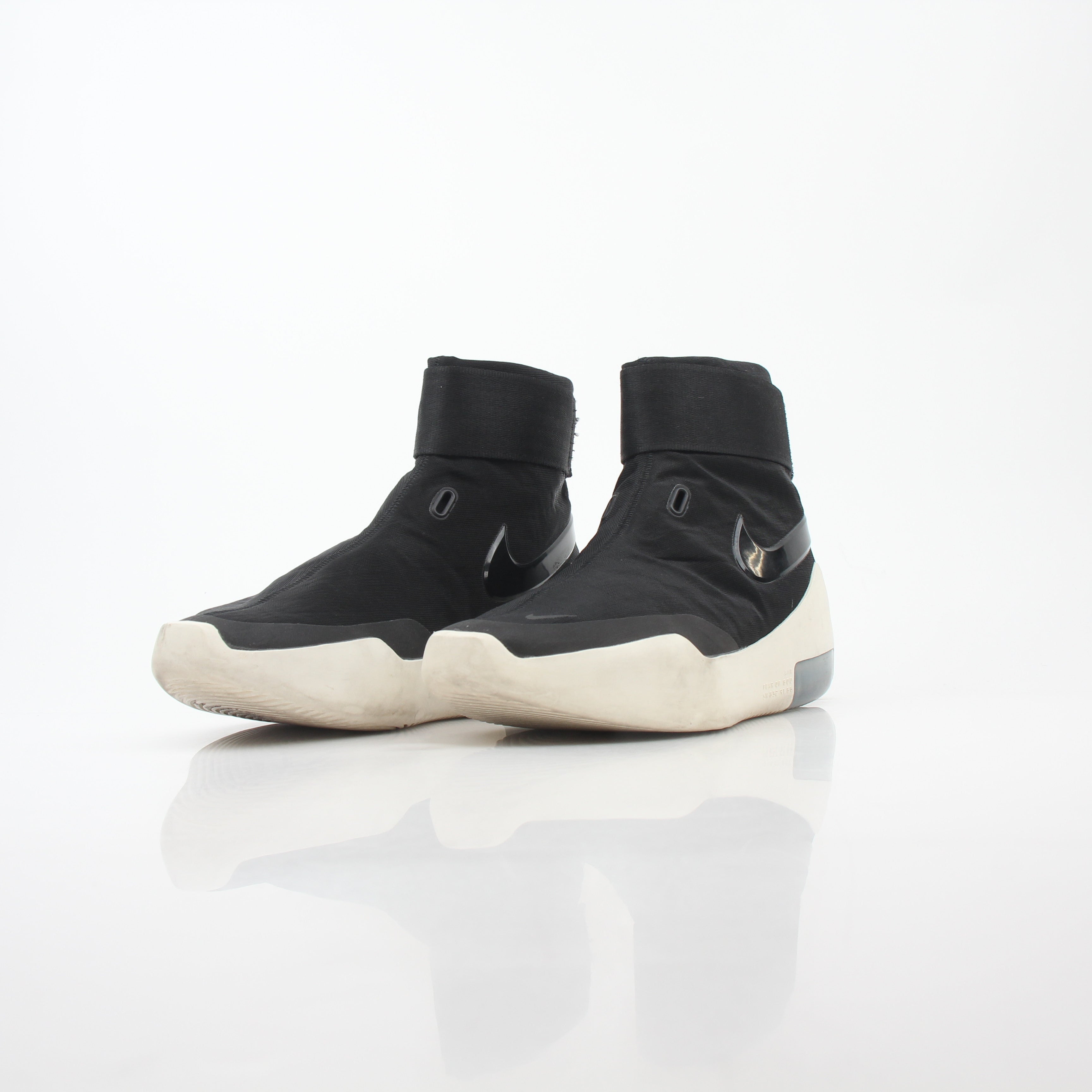 Black Nike x Fear of God Air Fear of God 1 high-top sneakers, showing sleek design and Nike branding on the shoes.