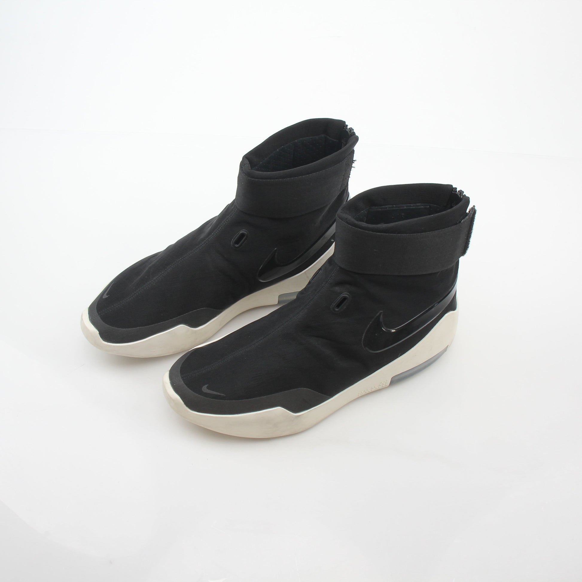 Black Nike x Fear of God Air Fear of God 1 high-top sneakers with Nike branding and sleek design, placed on a neutral background.