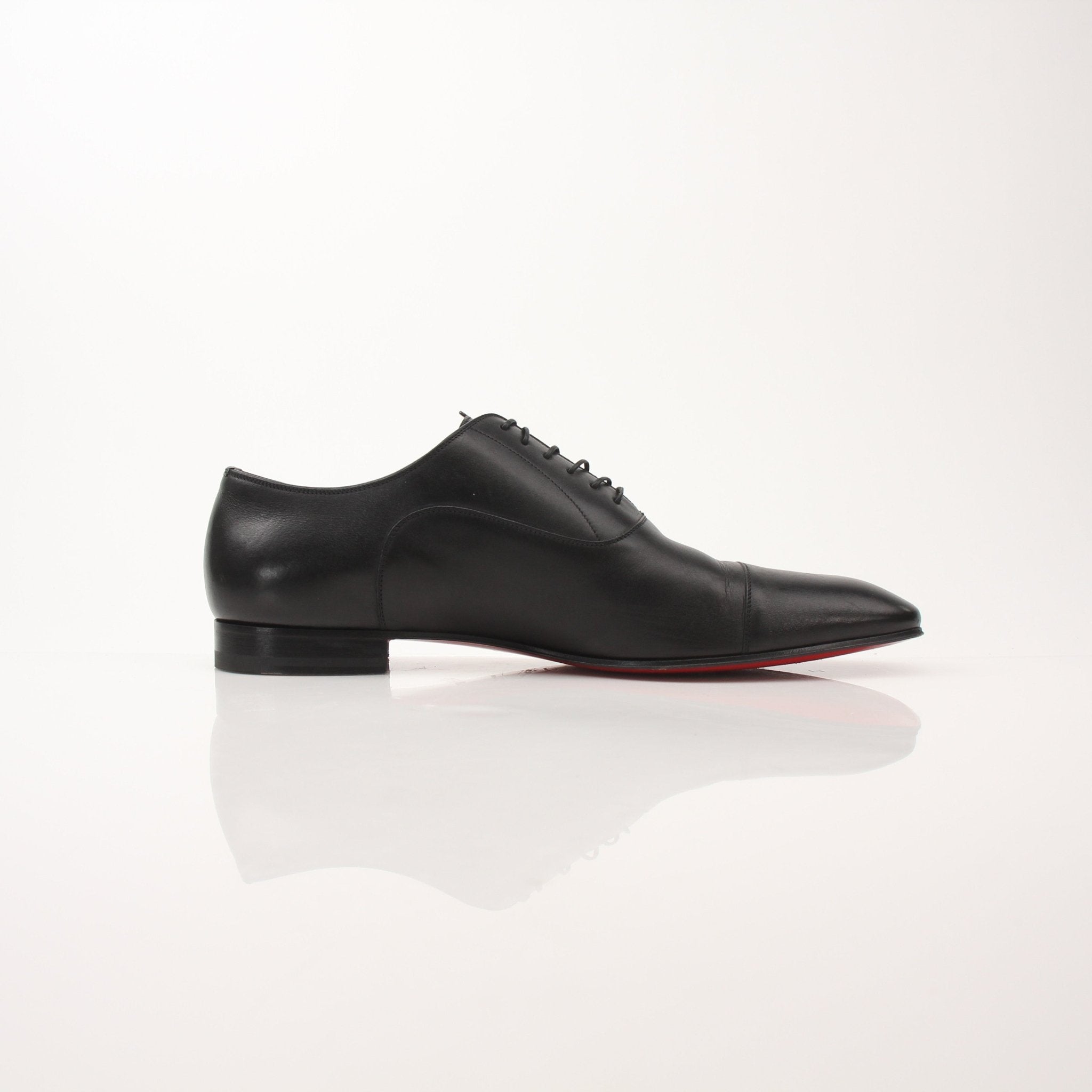 Christian Louboutin Greggo Oxford shoes for men, stylish black leather dress shoes with signature red soles, by Gold & Beyond.