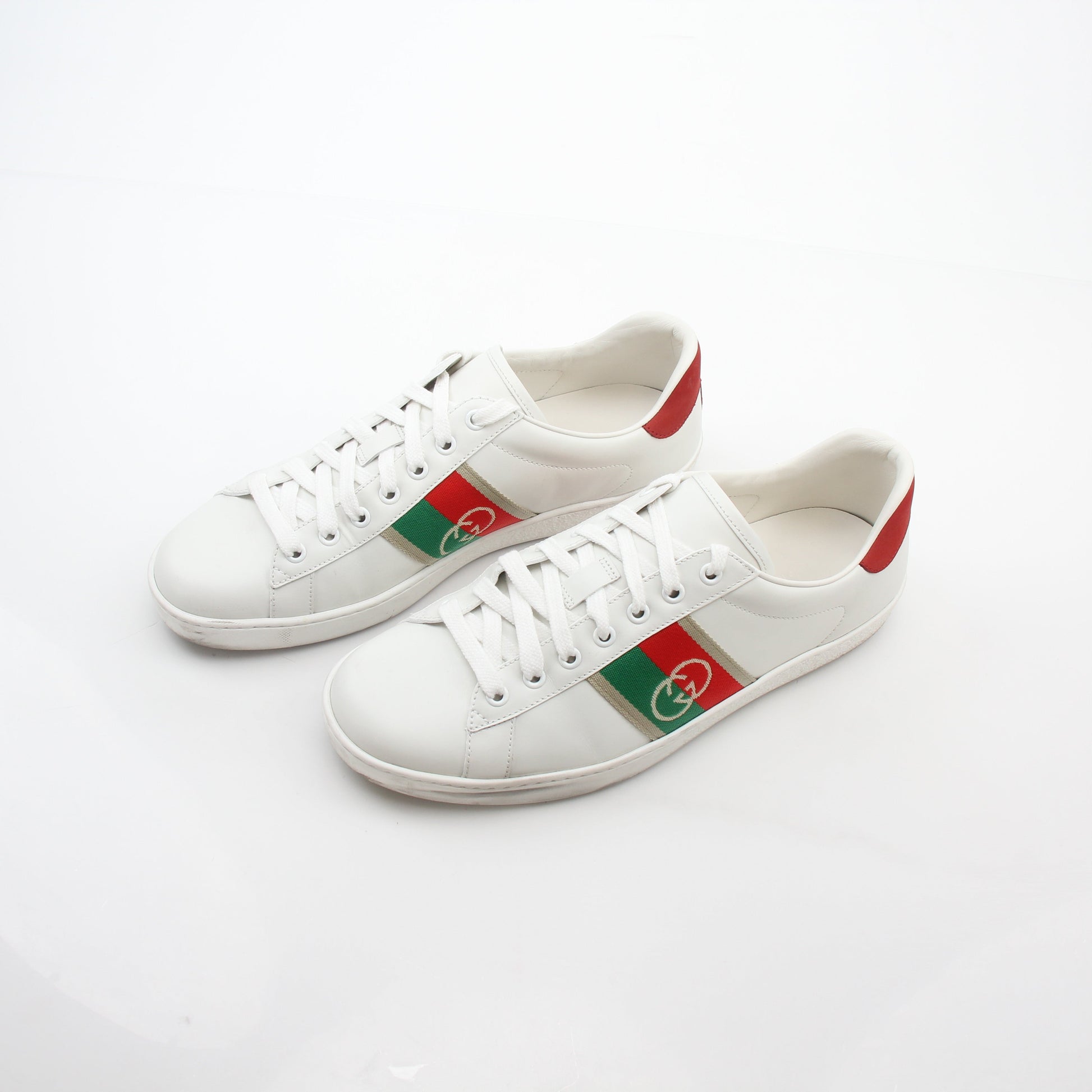 Gucci White Ace Interlocking G Web Leather Sneakers with gold accents, showcasing the stylish design and brand logo.