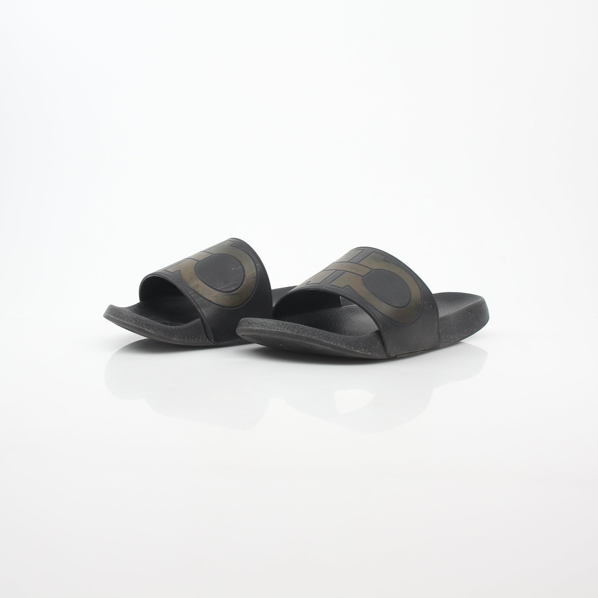 Black Salvatore Ferragamo Groove 2 Gancini slide sandals with leather straps and signature Gancini hardware, displayed on a neutral background.