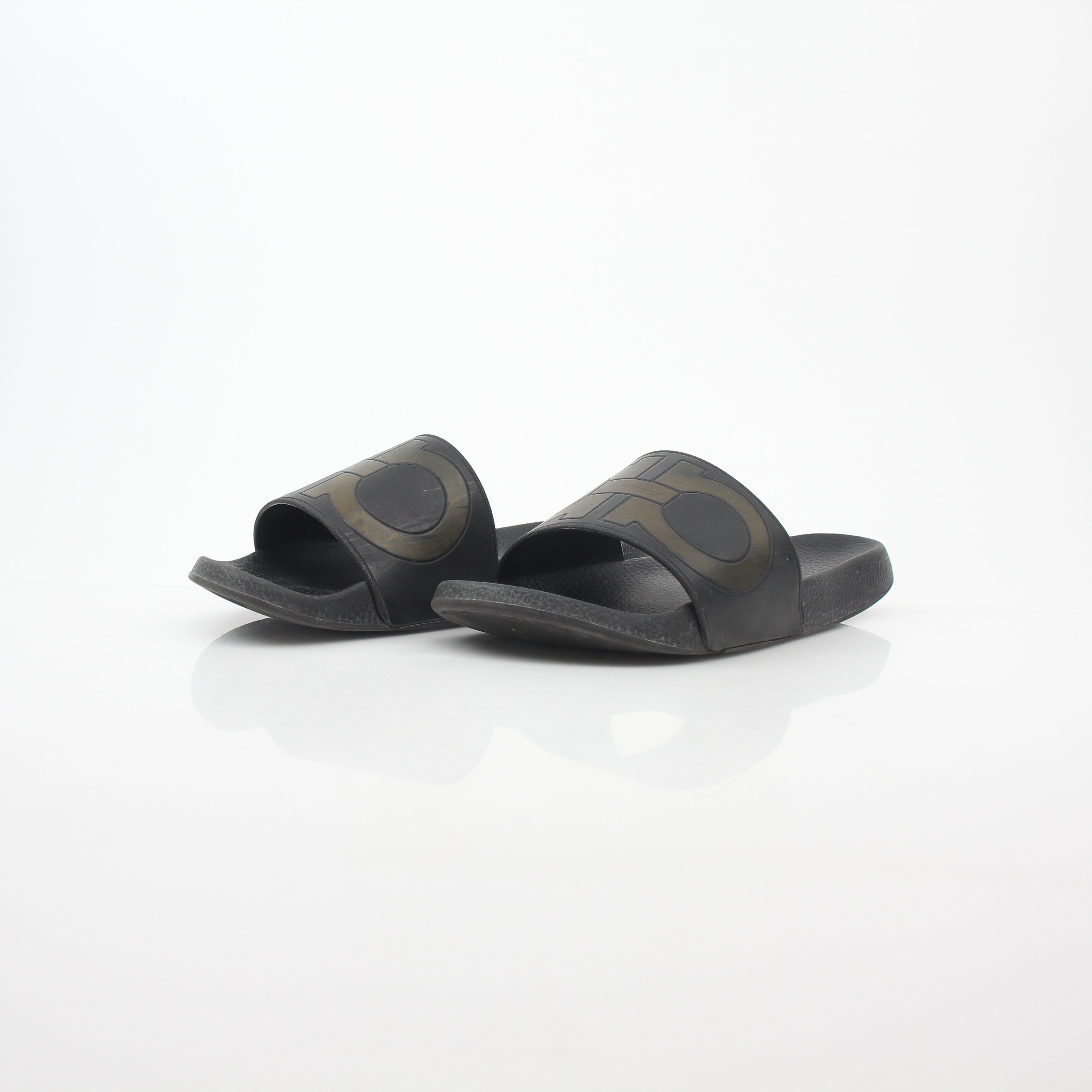Black Salvatore Ferragamo Groove 2 Gancini slide sandals with leather straps and signature Gancini hardware, displayed on a neutral background.