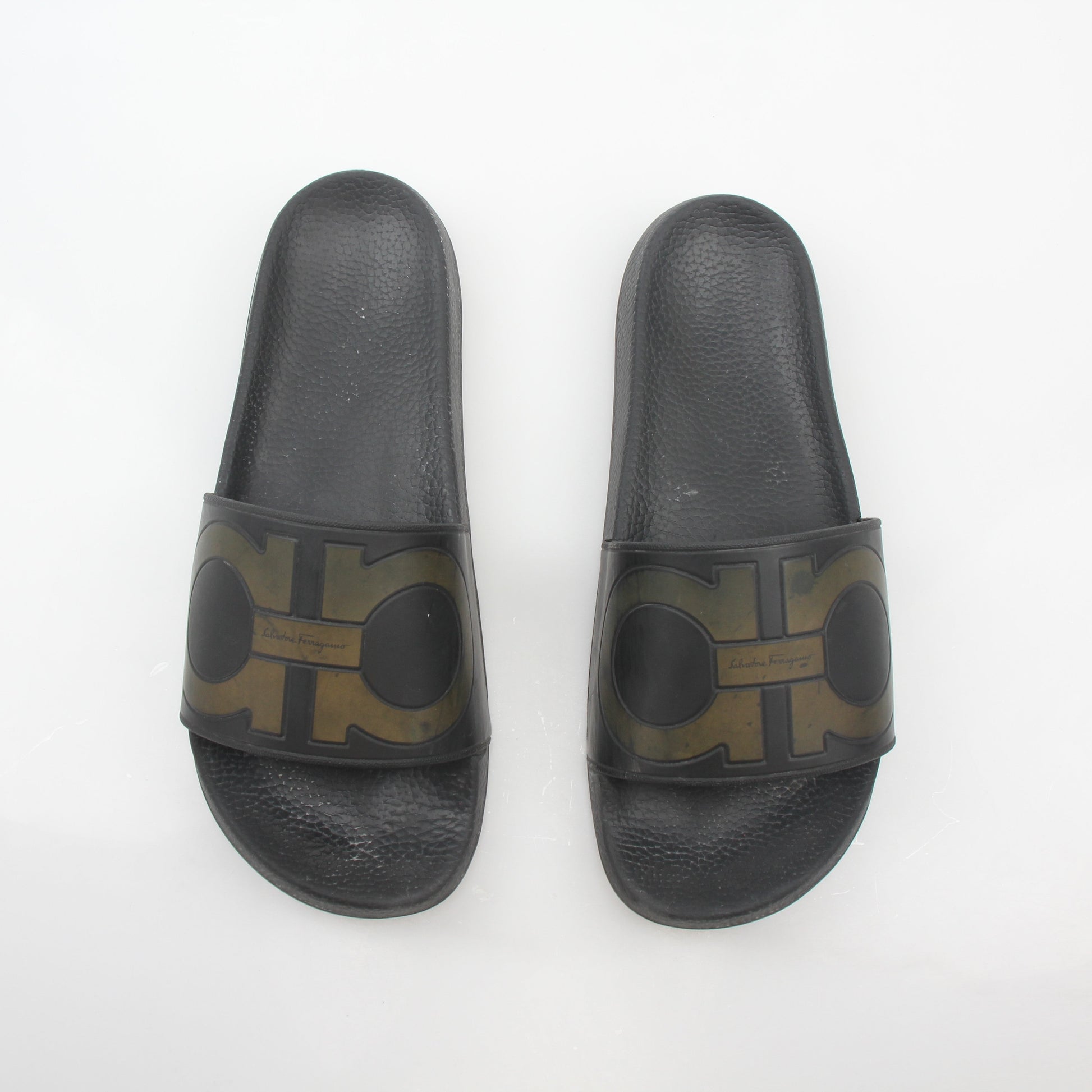 Black Salvatore Ferragamo Groove 2 Gancini slide sandals with sleek straps and signature Gancini hardware, displayed on a white background.