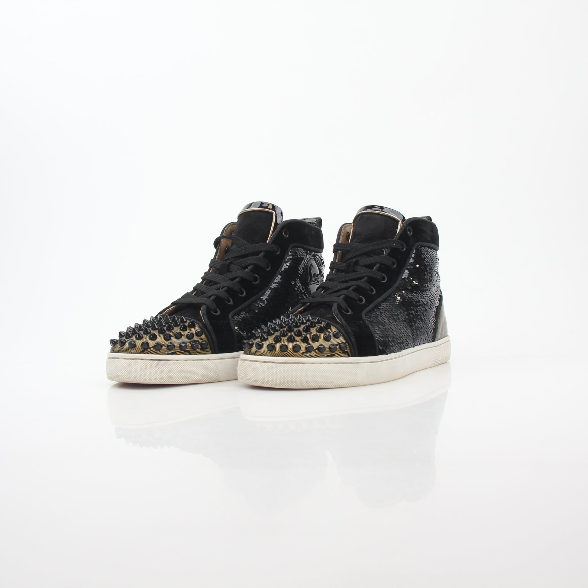 Black Christian Louboutin Lou Spikes Orlato high-top sneakers with spikes and gold accents, displayed on a white background.