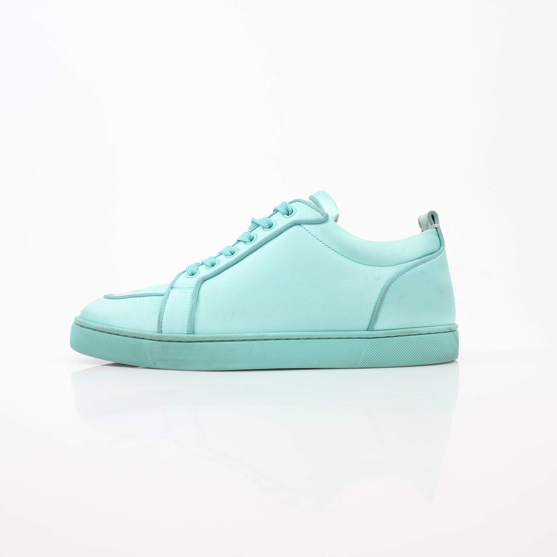 Christian Louboutin turquoise Rantulow Orlato low-top sneakers featuring iconic red soles and stylish design, displayed on a plain background.