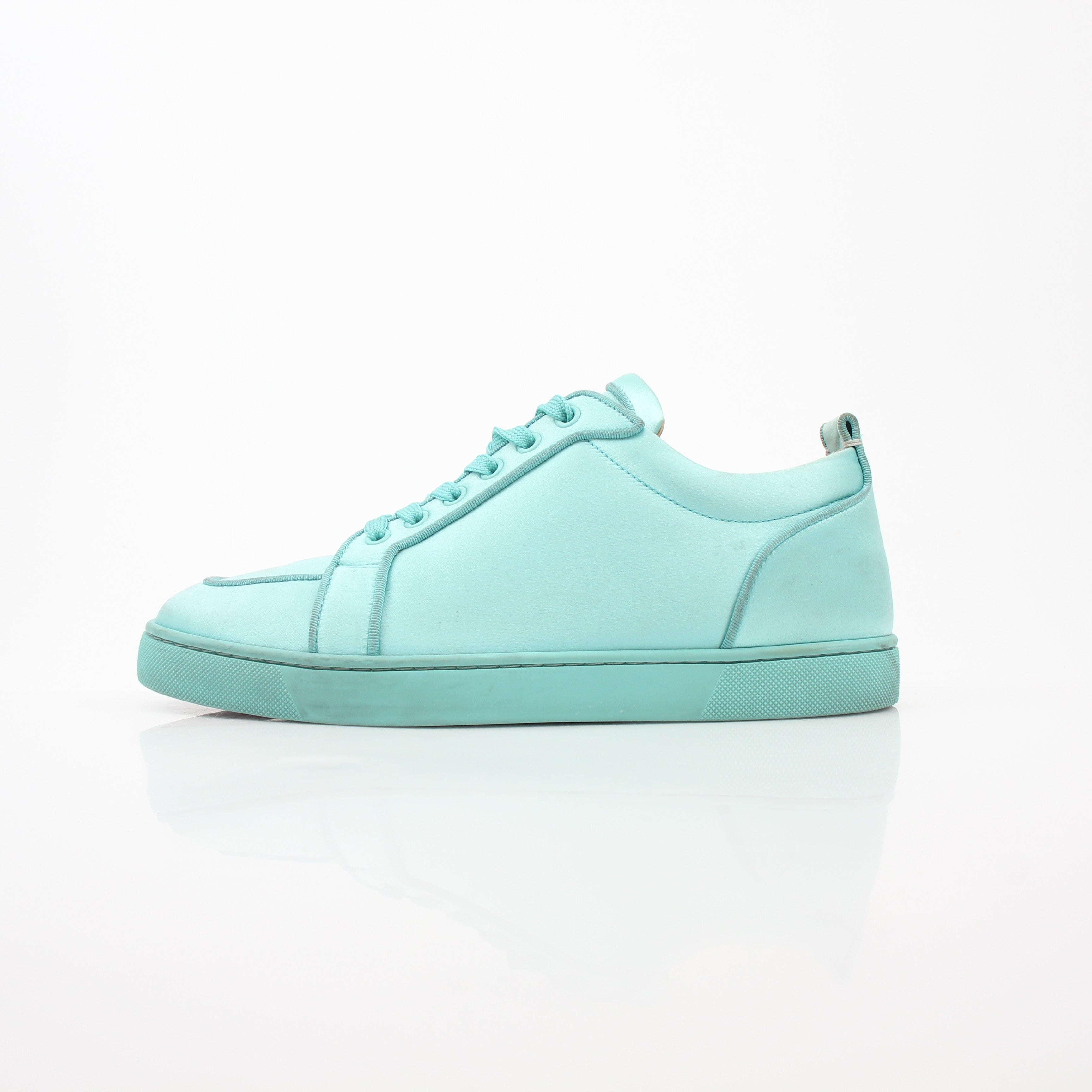 Christian Louboutin turquoise Rantulow Orlato low-top sneakers featuring iconic red soles and stylish design, displayed on a plain background.
