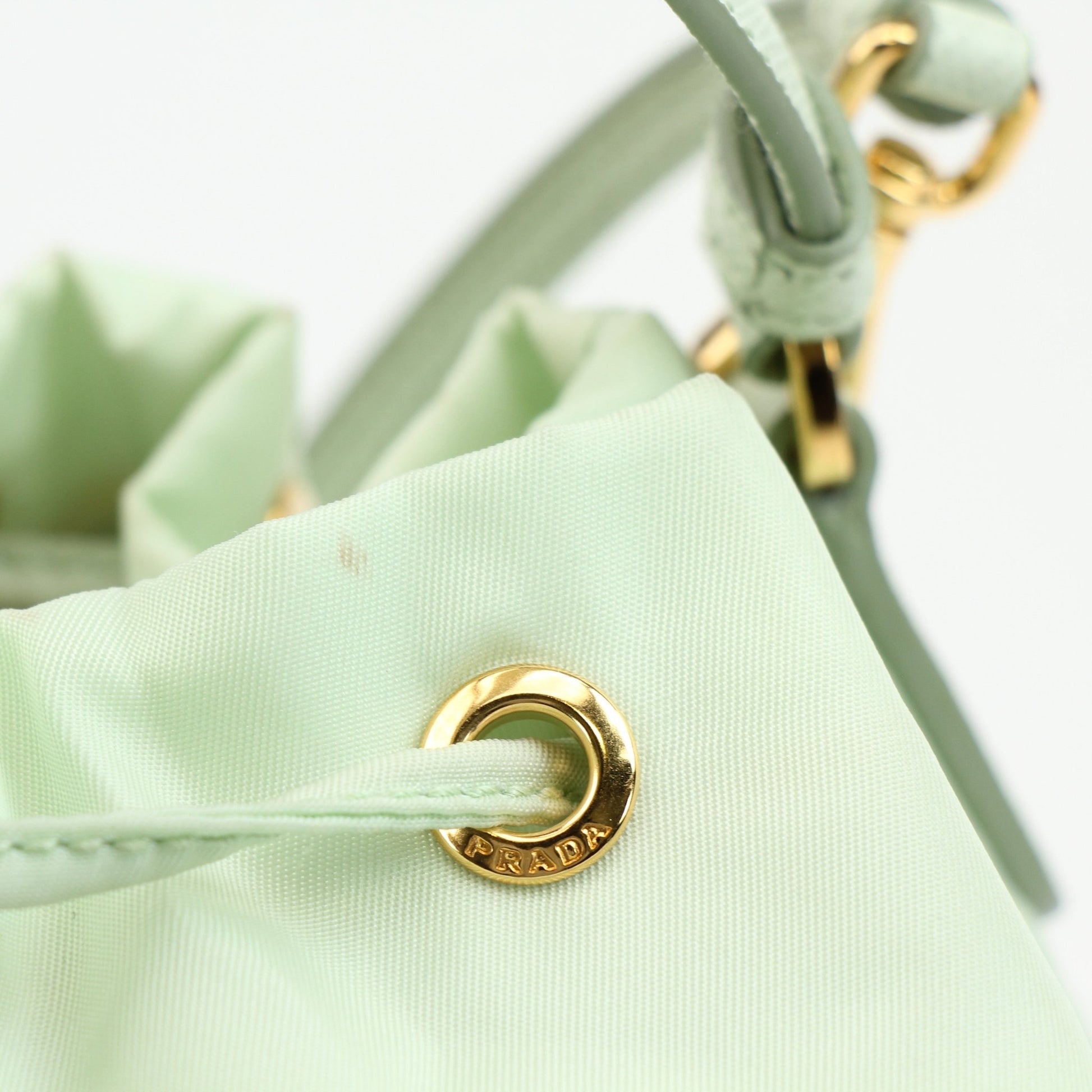 Prada nylon drawstring handbag with adjustable straps and logo detail, showcasing a sleek, modern design.