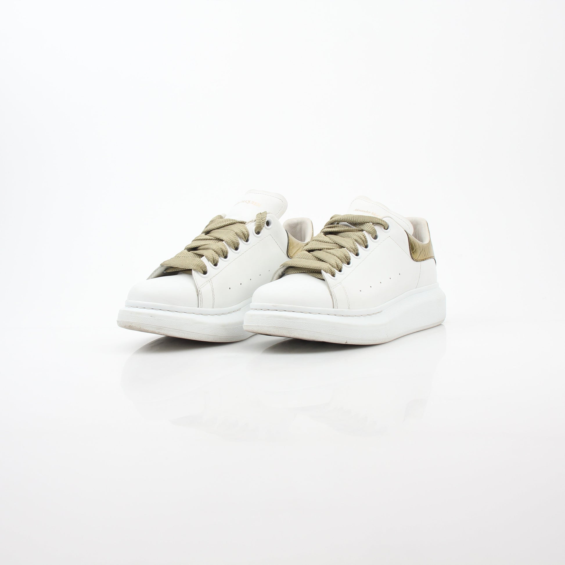 Alexander McQueen white gold oversized low-top sneakers with chunky design and bold style, featuring white and gold details.