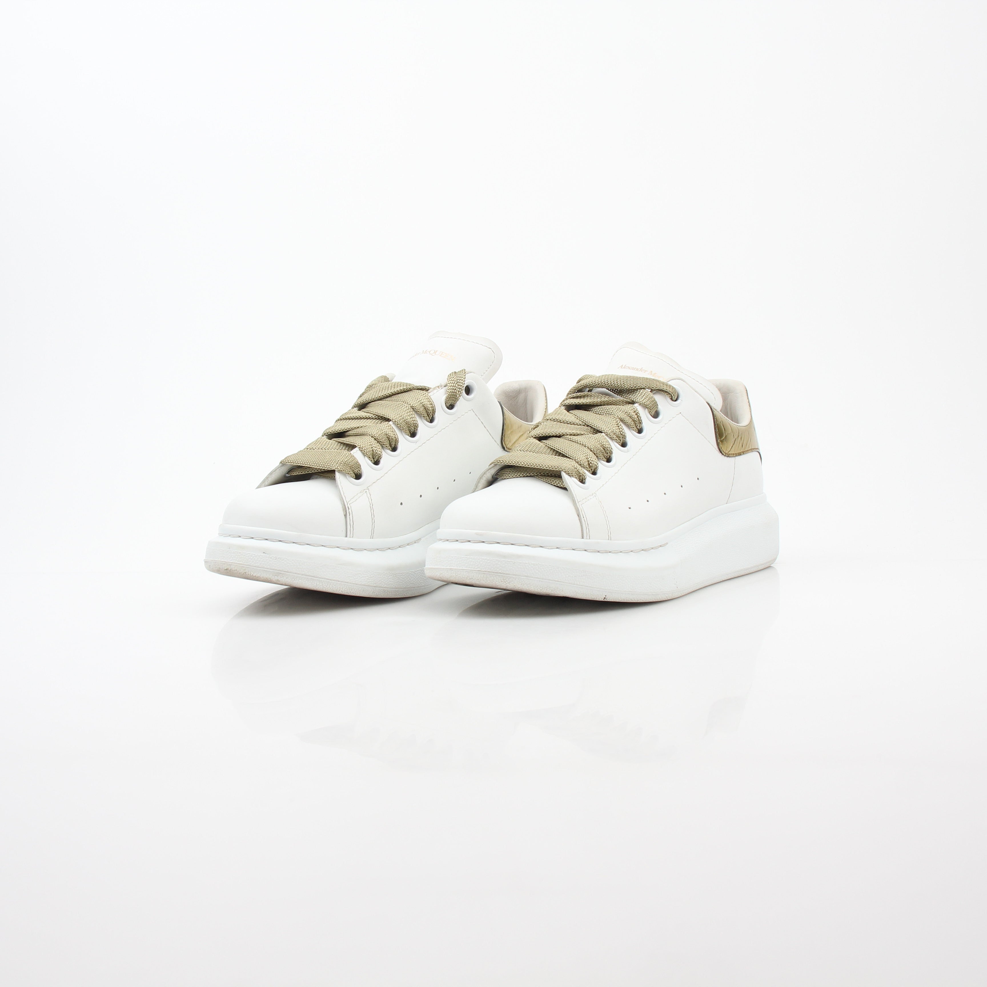 Alexander McQueen white gold oversized low-top sneakers with chunky design and bold style, featuring white and gold details.