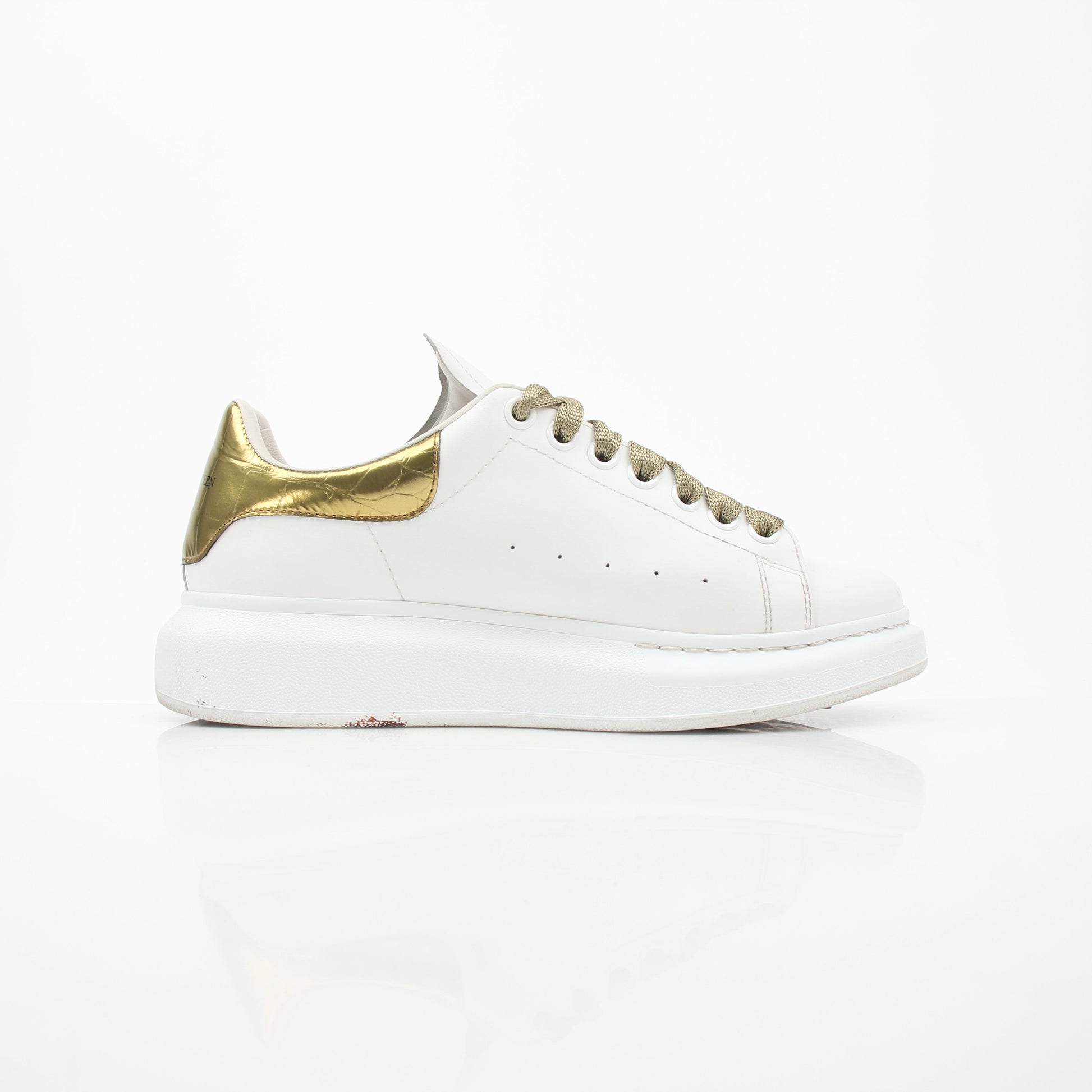 Alexander McQueen white gold oversized low-top sneakers by Gold & Beyond, showing the stylish shoes with white and gold accents.