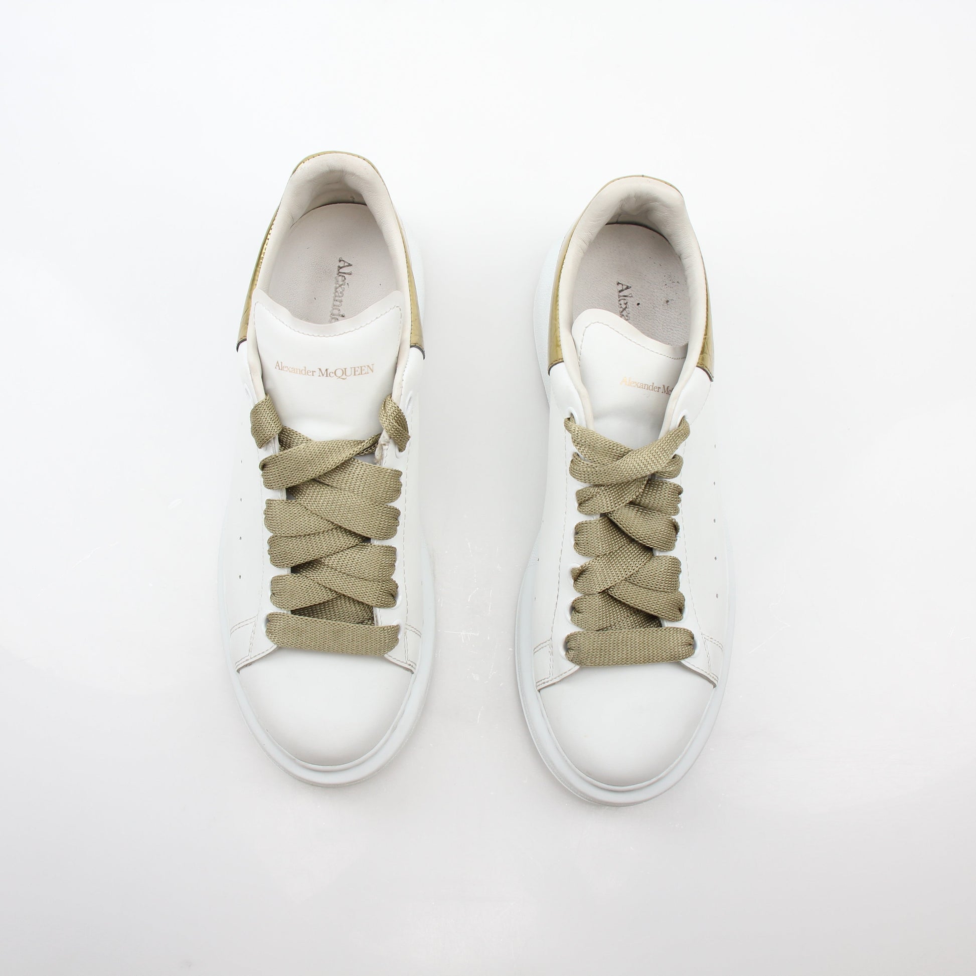 Alexander McQueen white gold oversized low-top sneakers by Gold & Beyond, featuring a sleek design with white and gold accents.