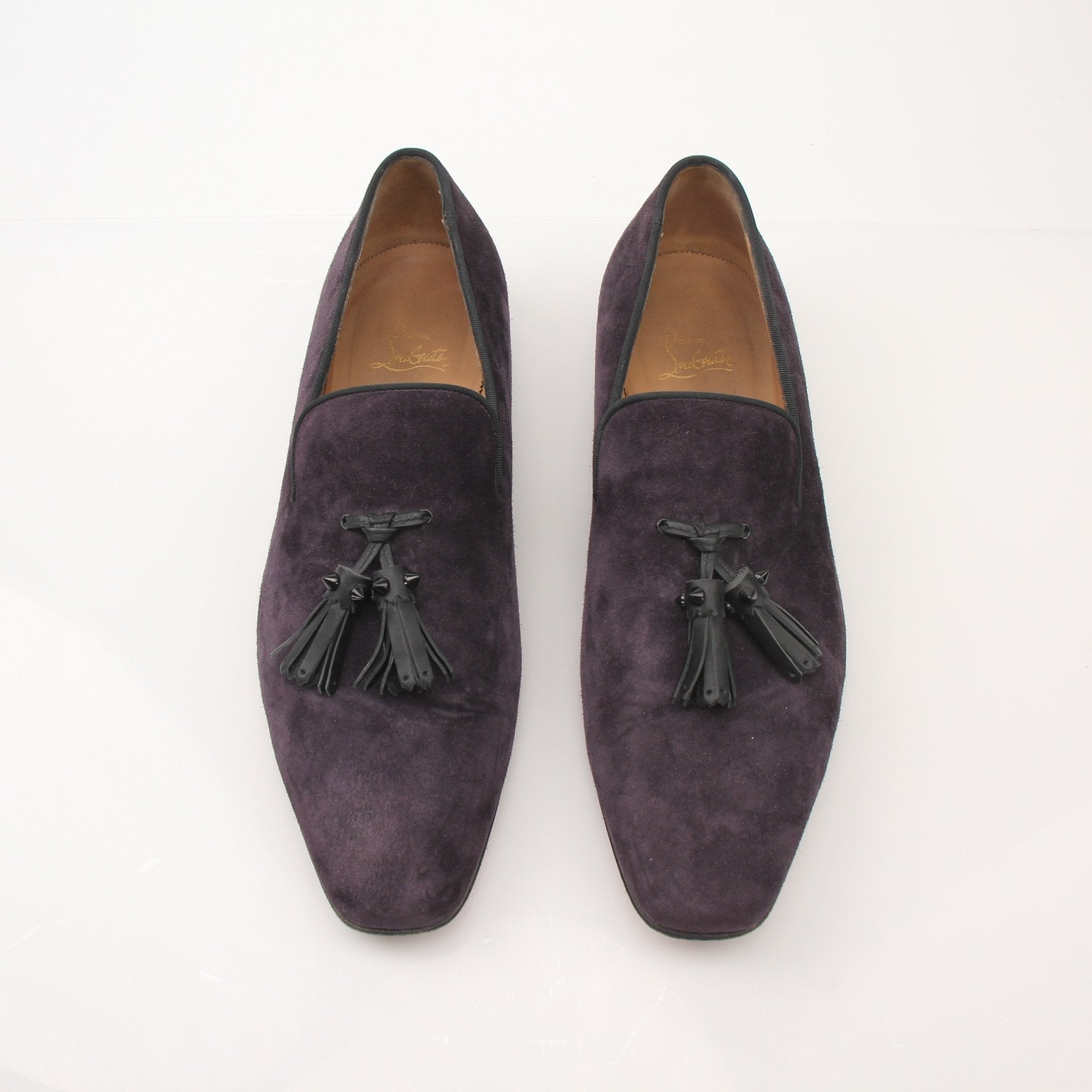 Christian Louboutin men's Dandelion tassel loafers with black leather and signature red soles, showcased on a neutral background.