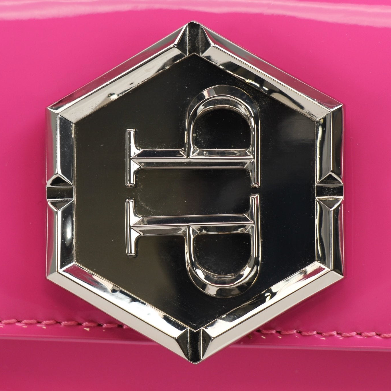 Pink patent leather Philipp Plein handbag with top handle, featuring gold accents and a stylish design.