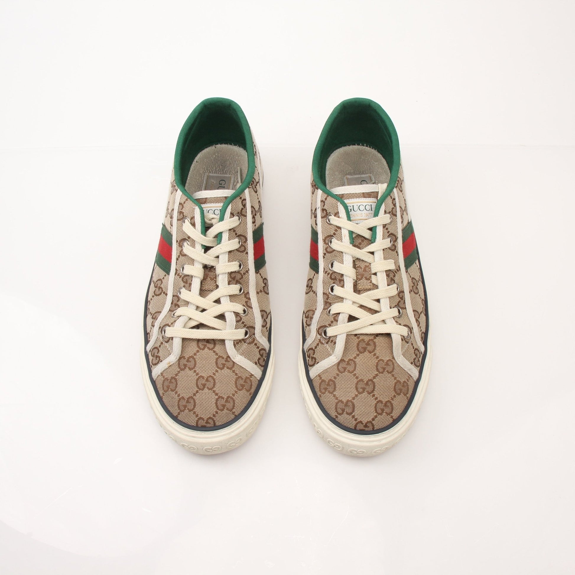 Gold & Beyond Gucci men's GG Tennis 1977 low-top sneakers with white leather and signature logo, shown from a side angle.