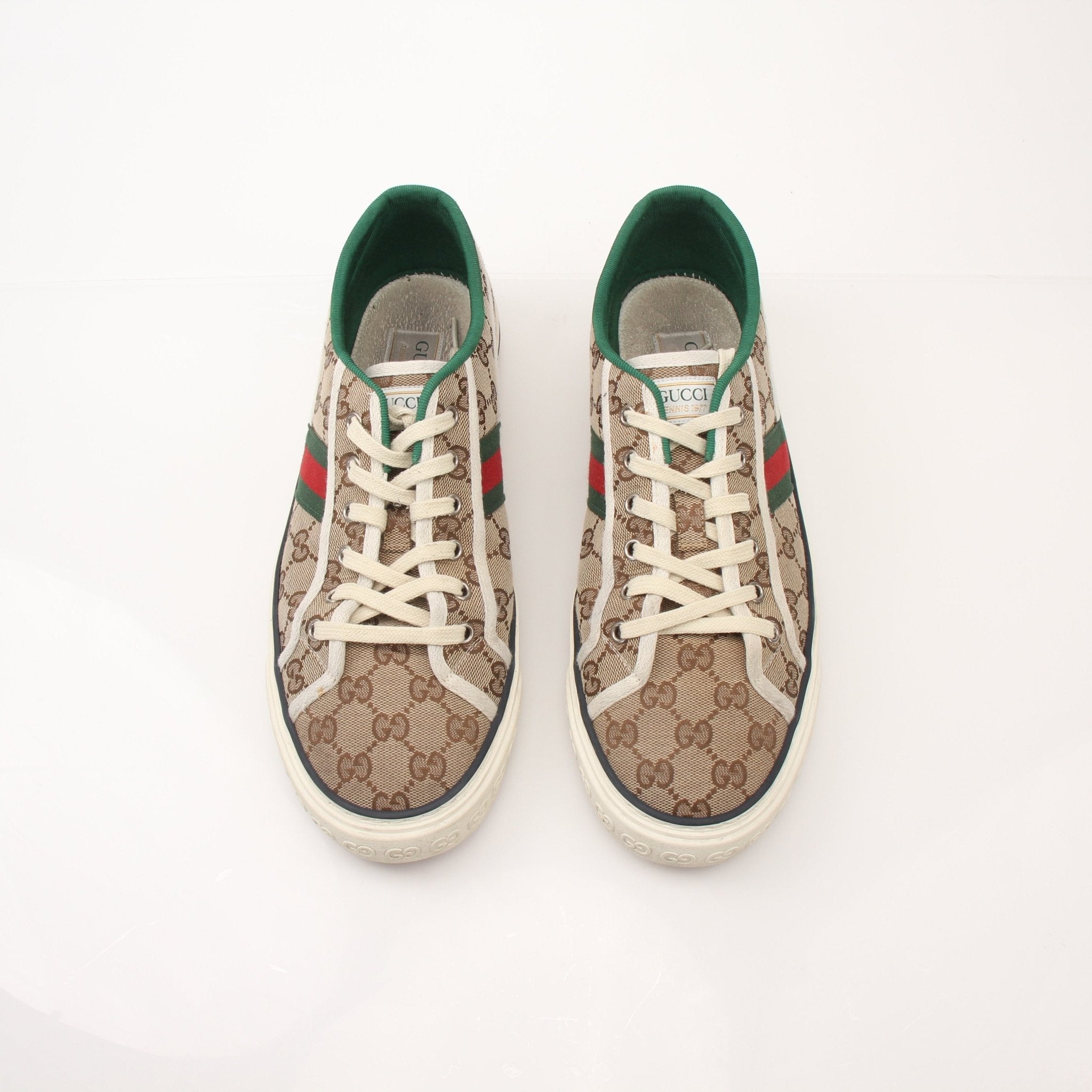 Gold & Beyond Gucci men's GG Tennis 1977 low-top sneakers with white leather and signature logo, shown from a side angle.