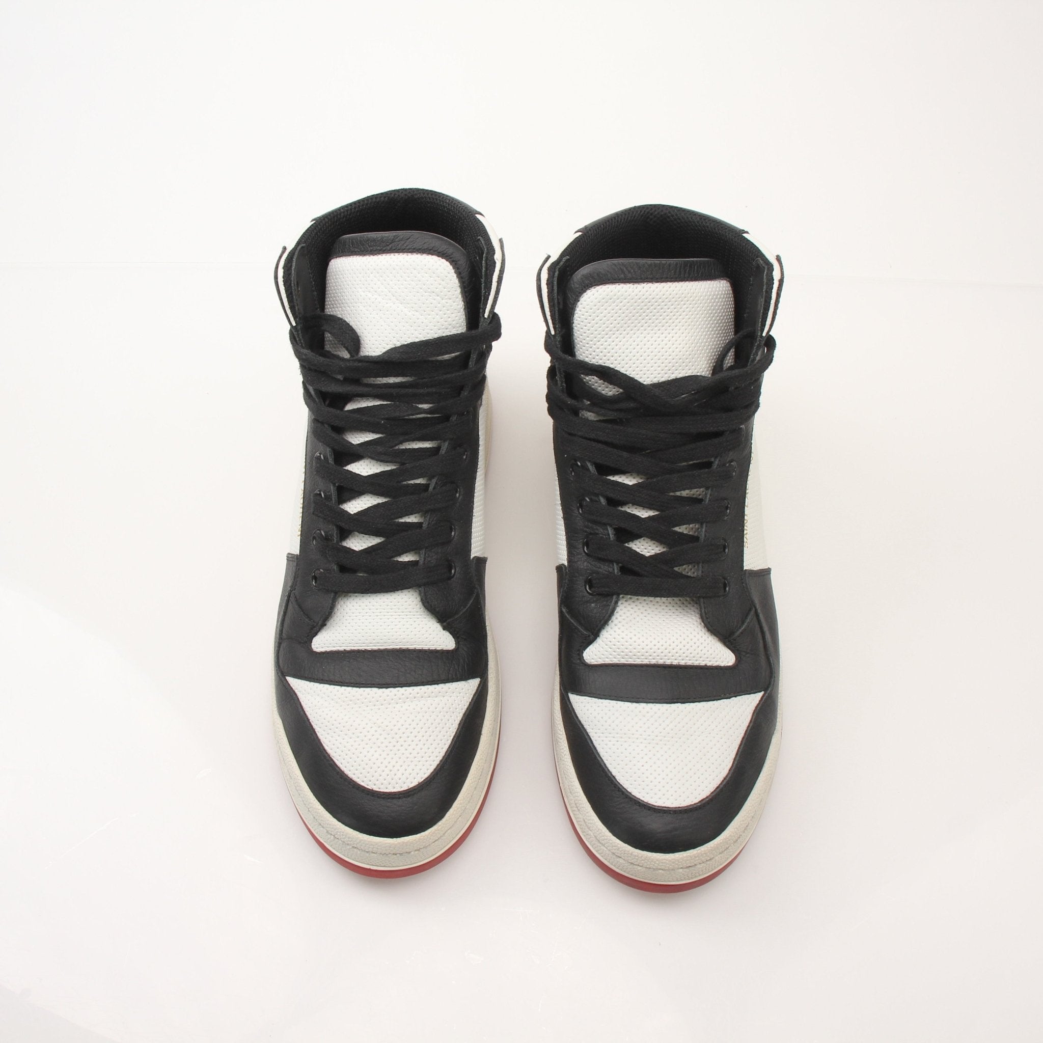 Saint Laurent men's SL-24 leather sneakers with white soles and sleek black design, displayed on a plain background.