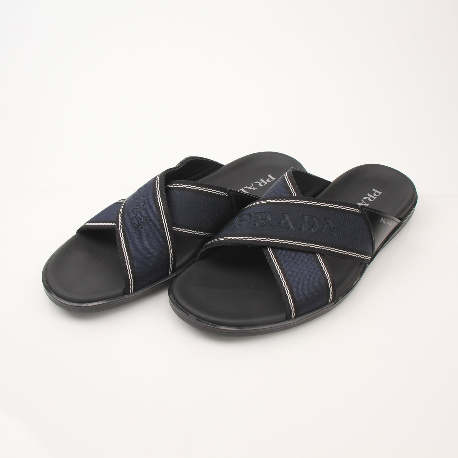 Prada men's leather and Re-Nylon sandals with open toes and adjustable straps, displayed on a neutral background.