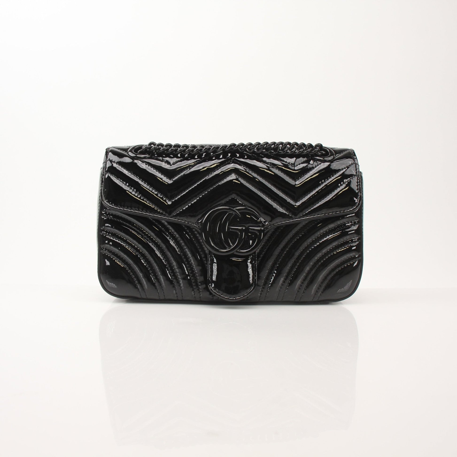 Black Gucci GG Marmont matelassé shoulder handbag with gold hardware and quilted design.