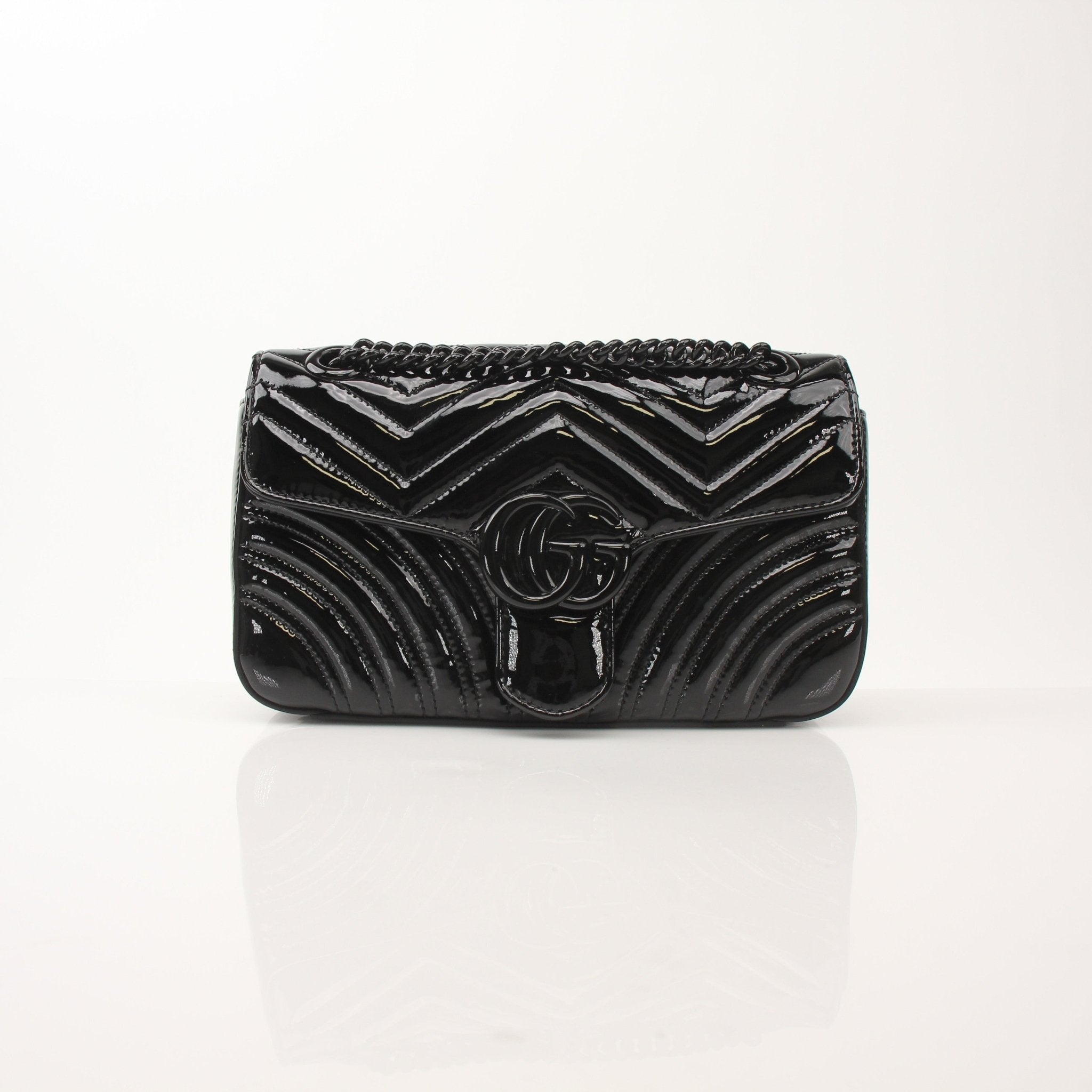 Black Gucci GG Marmont matelassé shoulder handbag with gold hardware and quilted design.