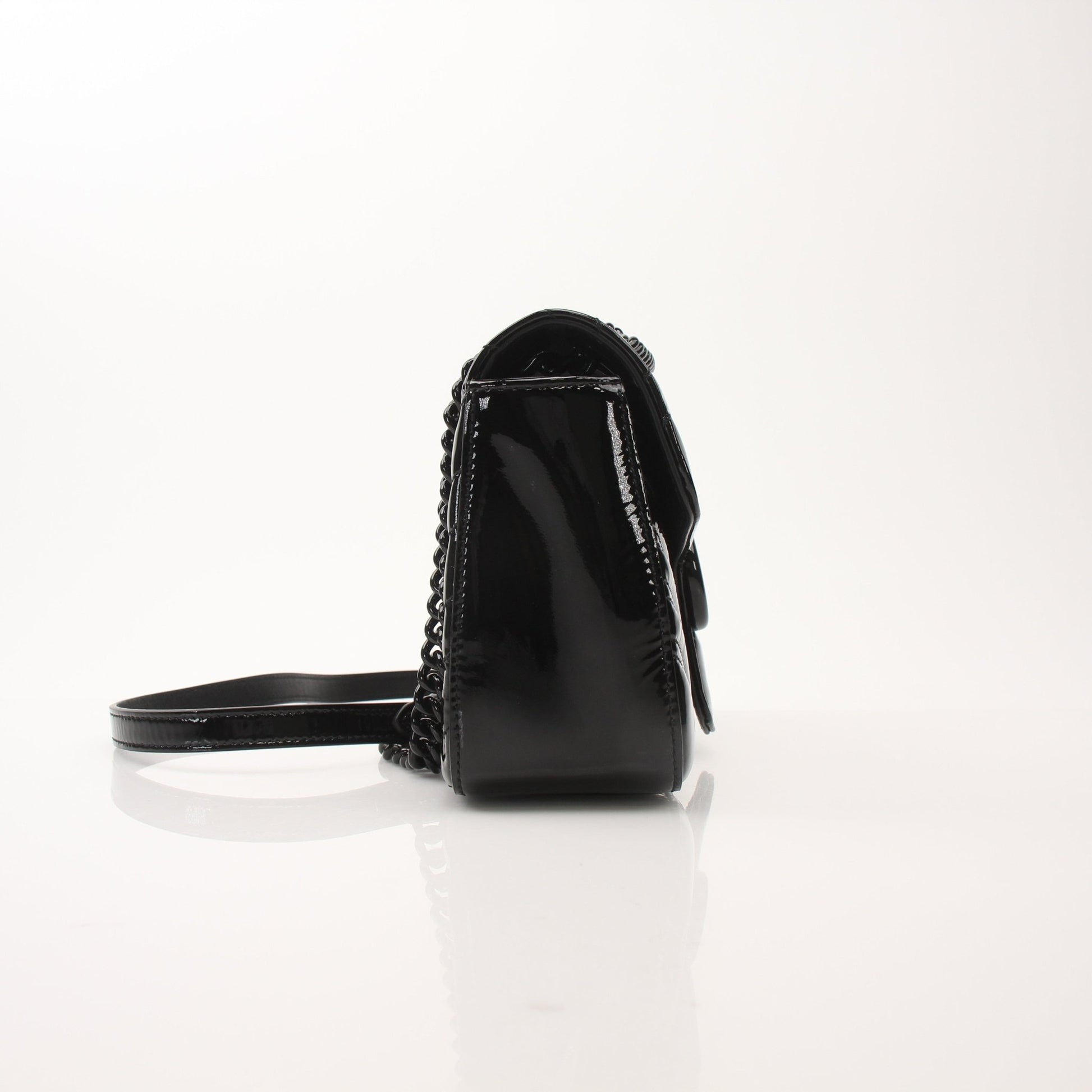 Black Gucci GG Marmont matelassé shoulder handbag with chain strap and chevron pattern, stylish and luxurious accessory.