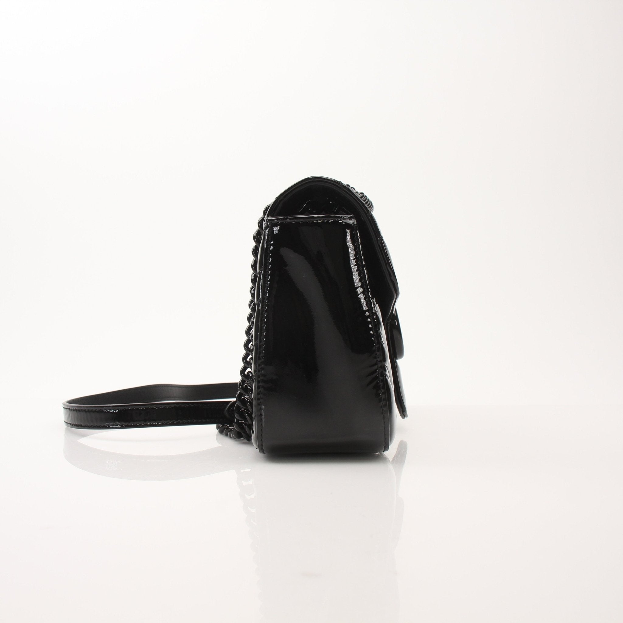 Black Gucci GG Marmont matelassé shoulder handbag with chain strap and chevron pattern, stylish and luxurious accessory.