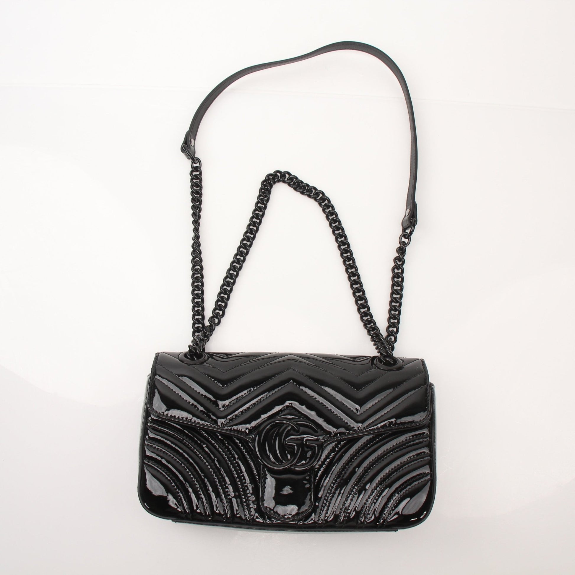 Gucci GG Marmont black matelassé shoulder handbag with gold hardware and chain strap, stylish and elegant accessory.