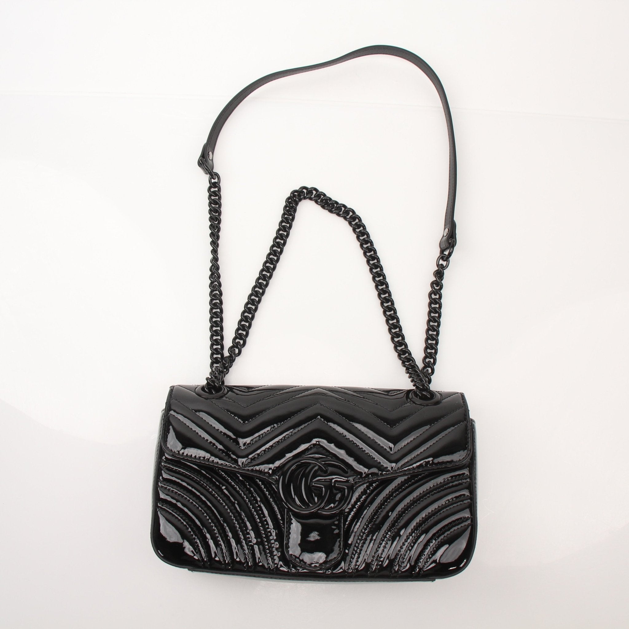 Gucci GG Marmont black matelassé shoulder handbag with gold hardware and chain strap, stylish and elegant accessory.