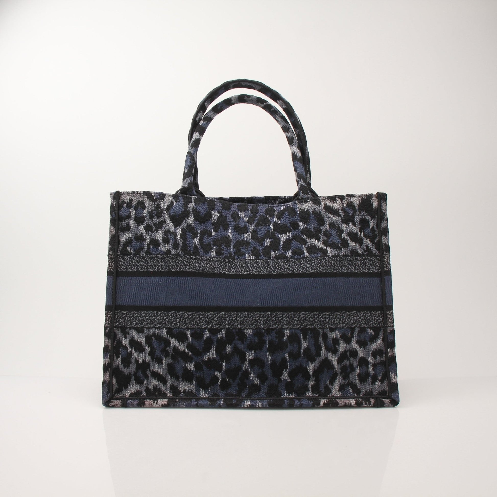 Christian Dior Leopard Book Tote handbag with gold accents, featuring bold animal print and spacious interior for everyday use.
