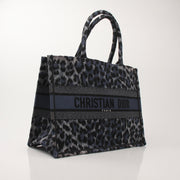 Christian Dior Leopard Book Tote handbag with gold accents, featuring a stylish leopard print design and structured shape.