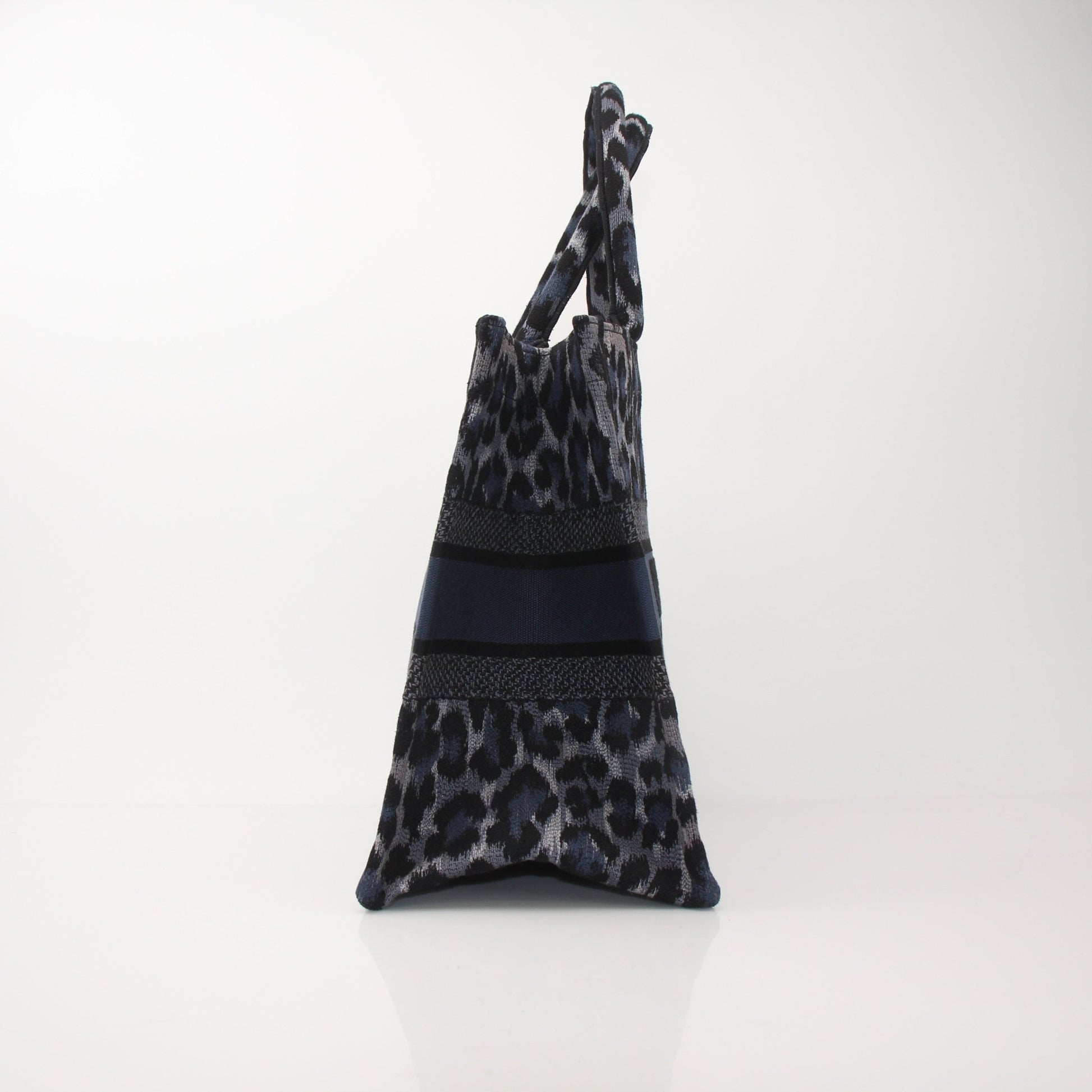 Christian Dior Leopard Book Tote handbag with gold accents, featuring a bold leopard print design and structured shape.