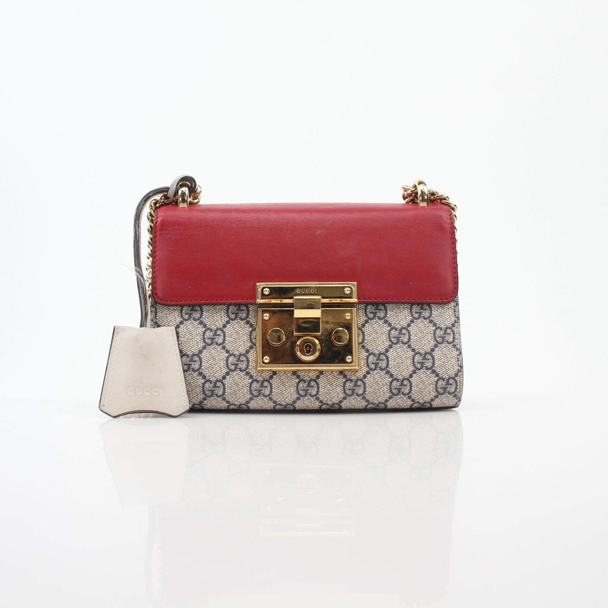 Red Gucci GG Supreme small shoulder handbag with padlock detail, featuring gold hardware and a compact, stylish design.