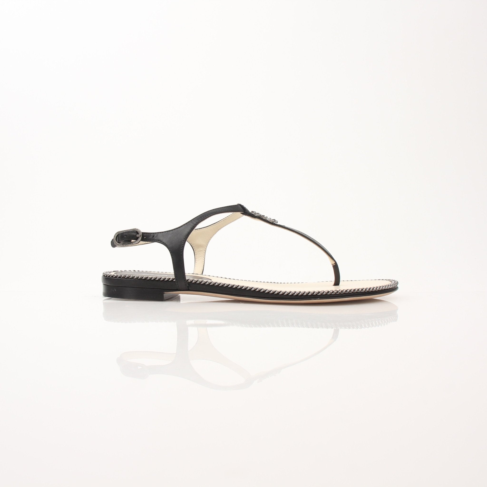 Gold & Beyond Chanel women’s chain trim thong sandals showing sleek leather straps and elegant chain accents.