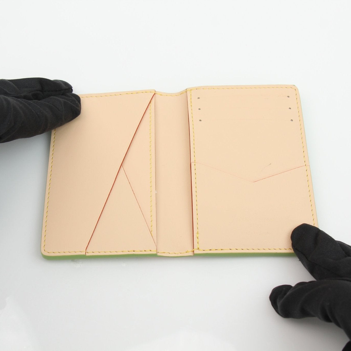 Green Louis Vuitton x Tyler The Creator pocket organizer card holder with multiple card slots and designer branding.
