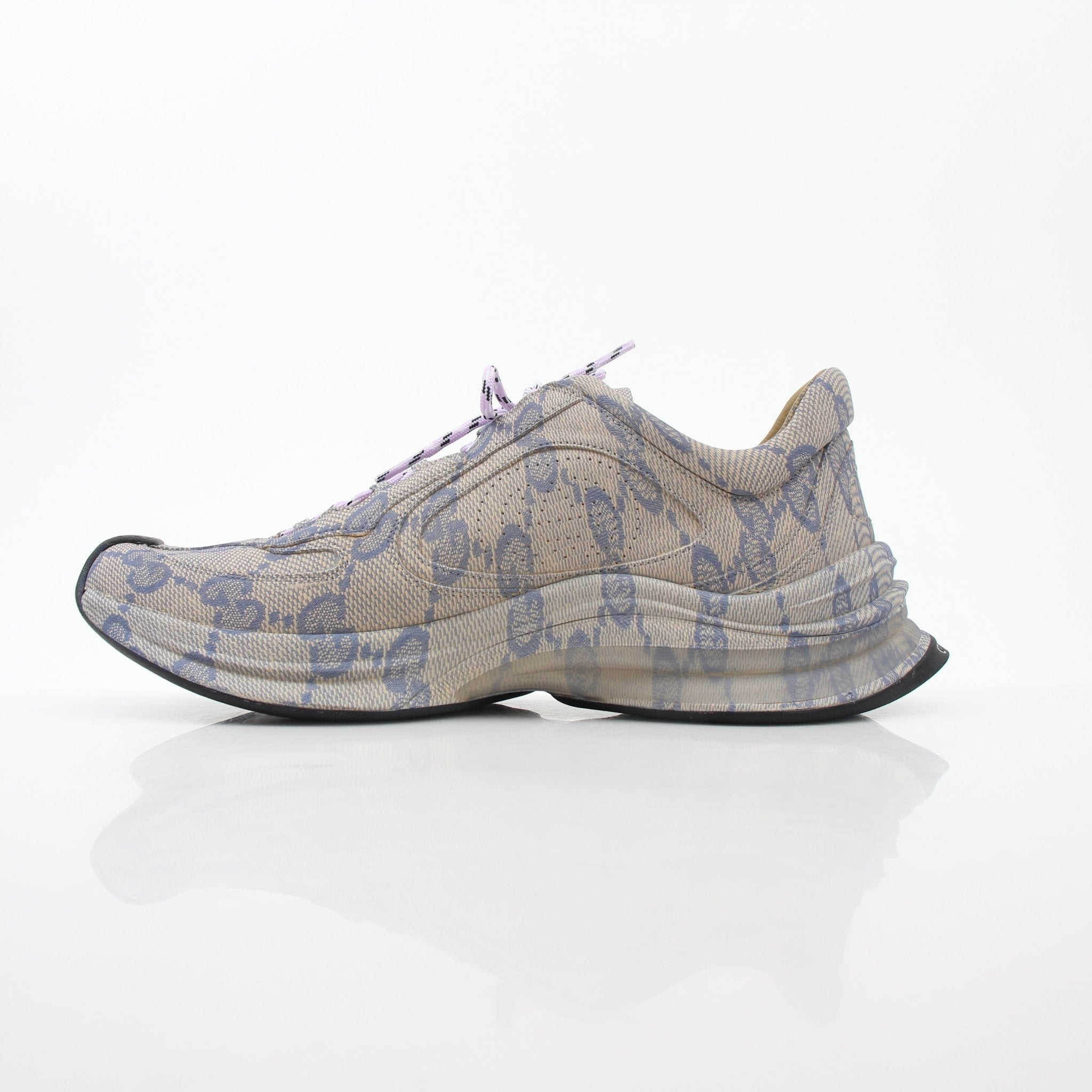 Beige and blue Gucci Run GG monogram low-top sneakers with gold accents, featuring classic branding and sporty design.