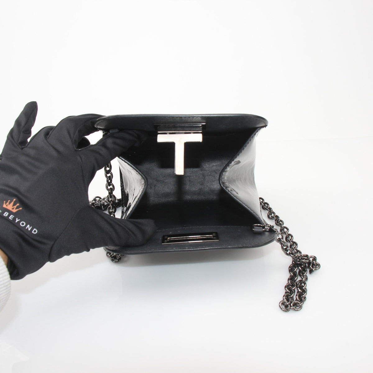 Tom Ford Black Cosmo handbag with gold accents, featuring sleek leather and elegant design, displayed on a neutral background.