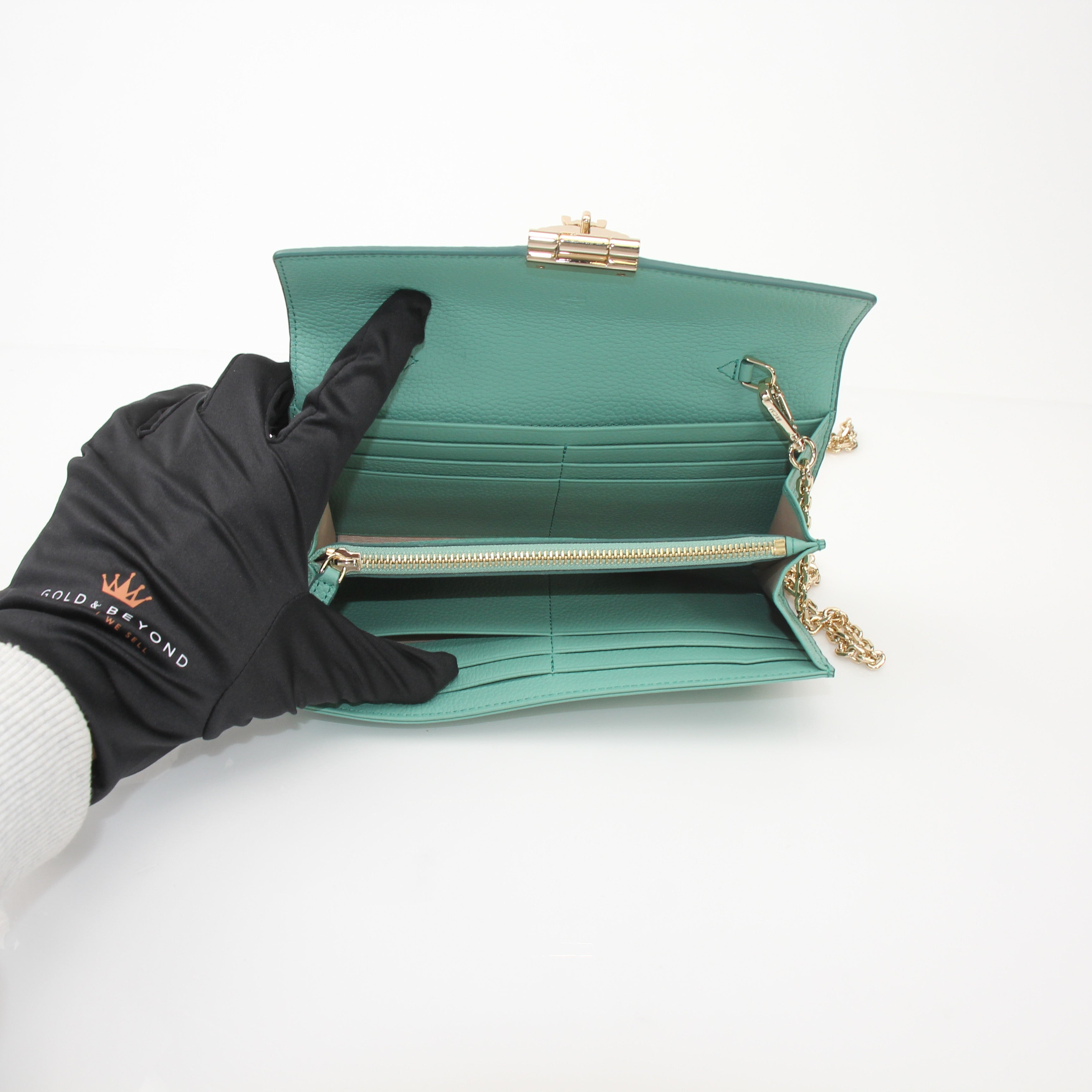 Gold & Beyond MCM Millie Mint wallet on chain, featuring a compact design with chain strap and signature logo details.