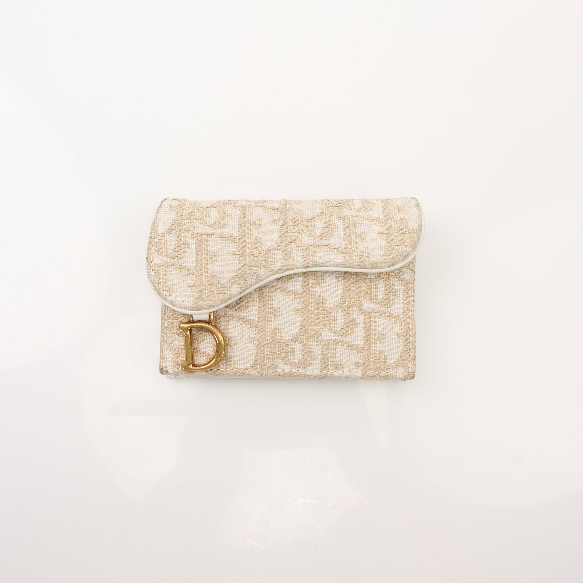 Christian Dior Compact Saddle Wallet by Gold & Beyond, featuring textured leather, gold hardware, and compact design for everyday use.