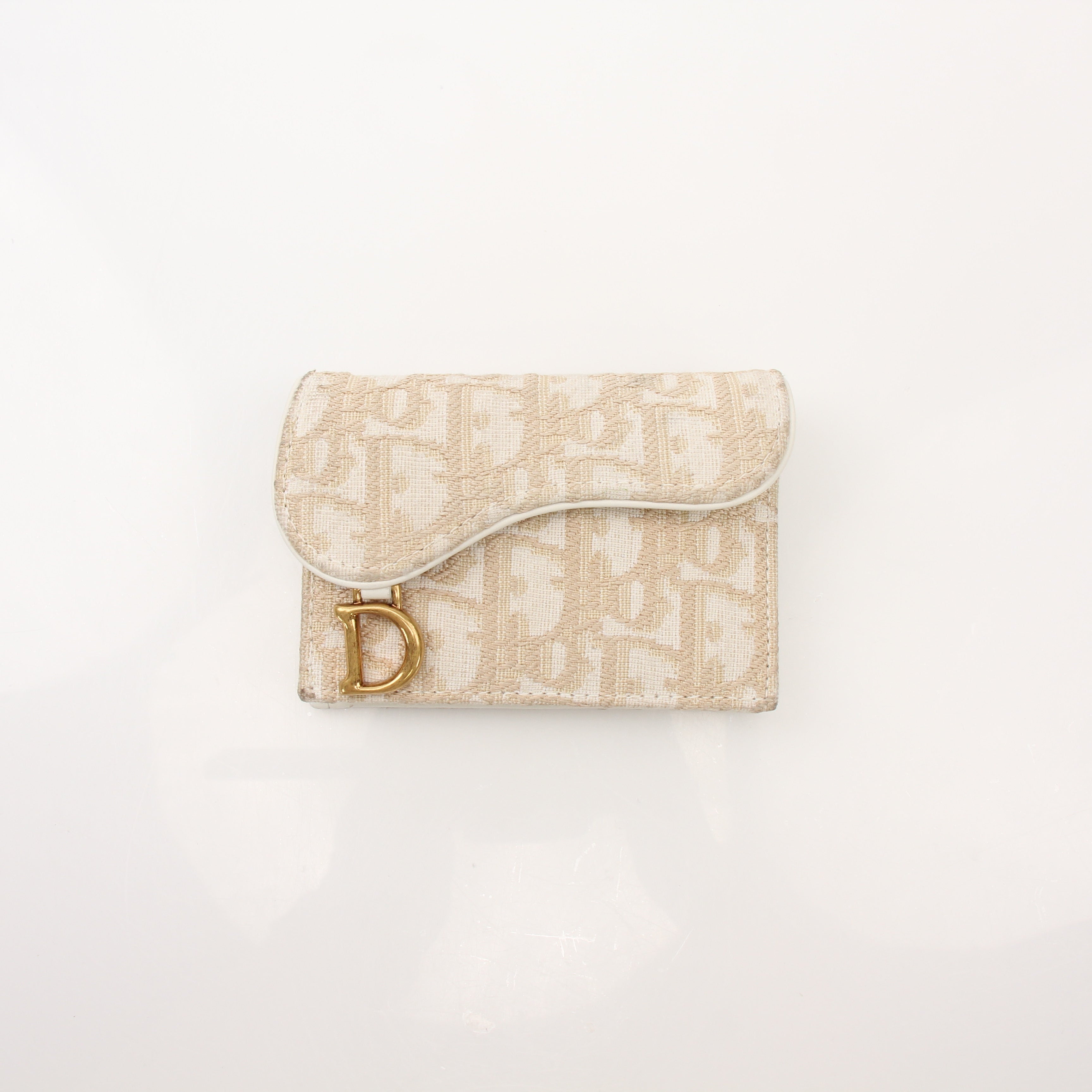 Christian Dior Compact Saddle Wallet by Gold & Beyond, featuring textured leather, gold hardware, and compact design for everyday use.
