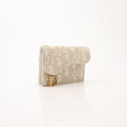 Christian Dior compact saddle wallet from Gold & Beyond, showing detailed leather design and compact wallet features.