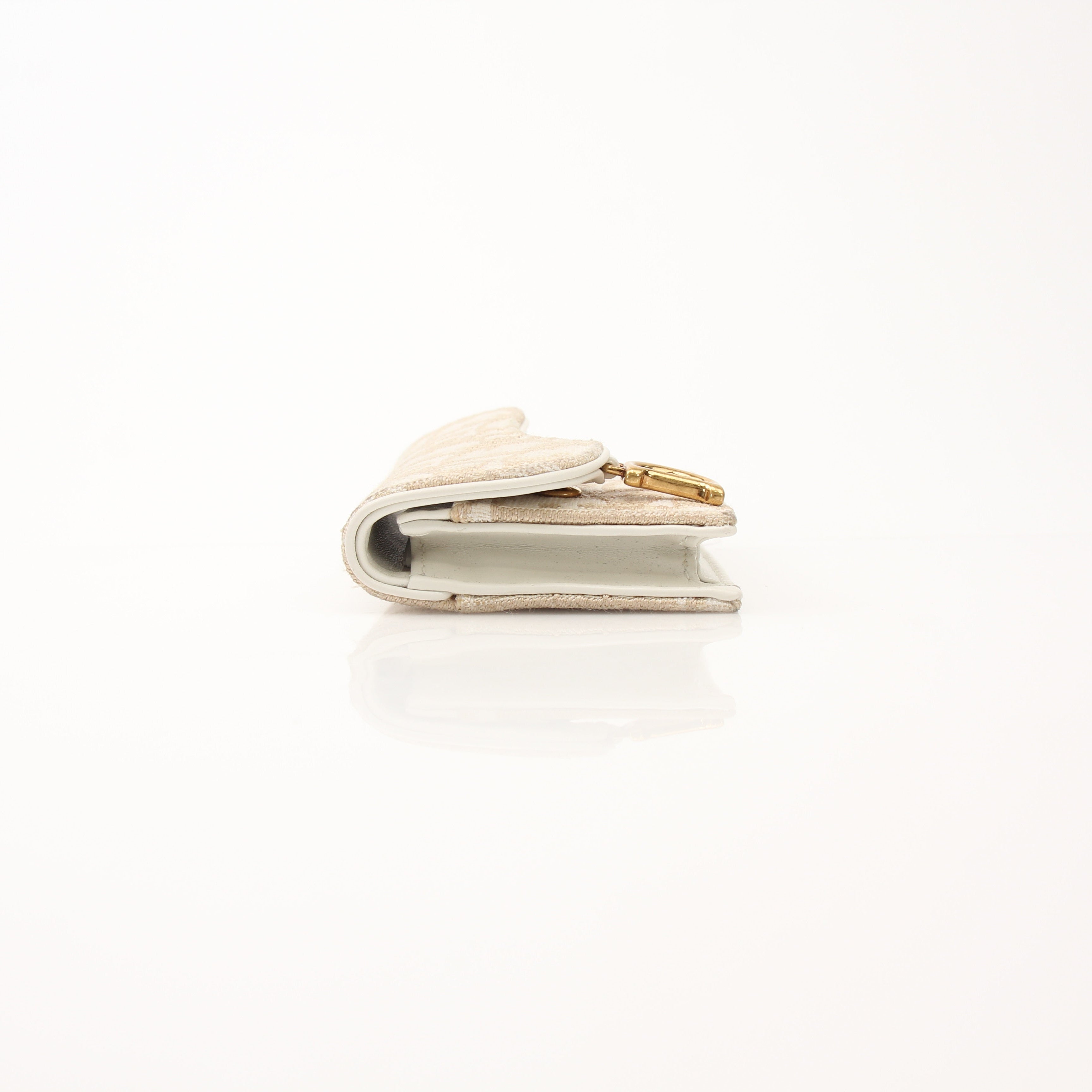 Christian Dior Compact Saddle Wallet by Gold & Beyond, showing the leather exterior with saddle design and compact size.