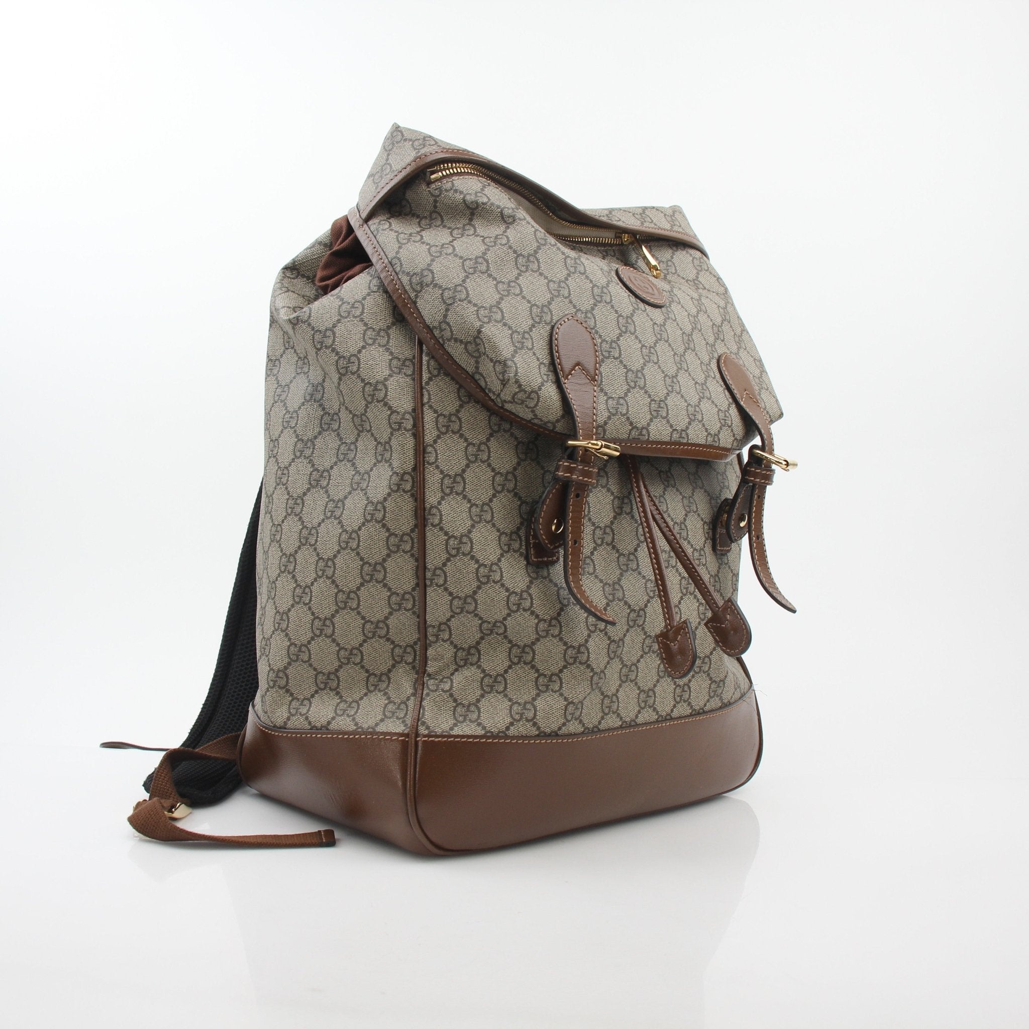 Gucci GG Supreme interlocking G double buckle backpack in black leather with gold hardware, stylish travel bag.