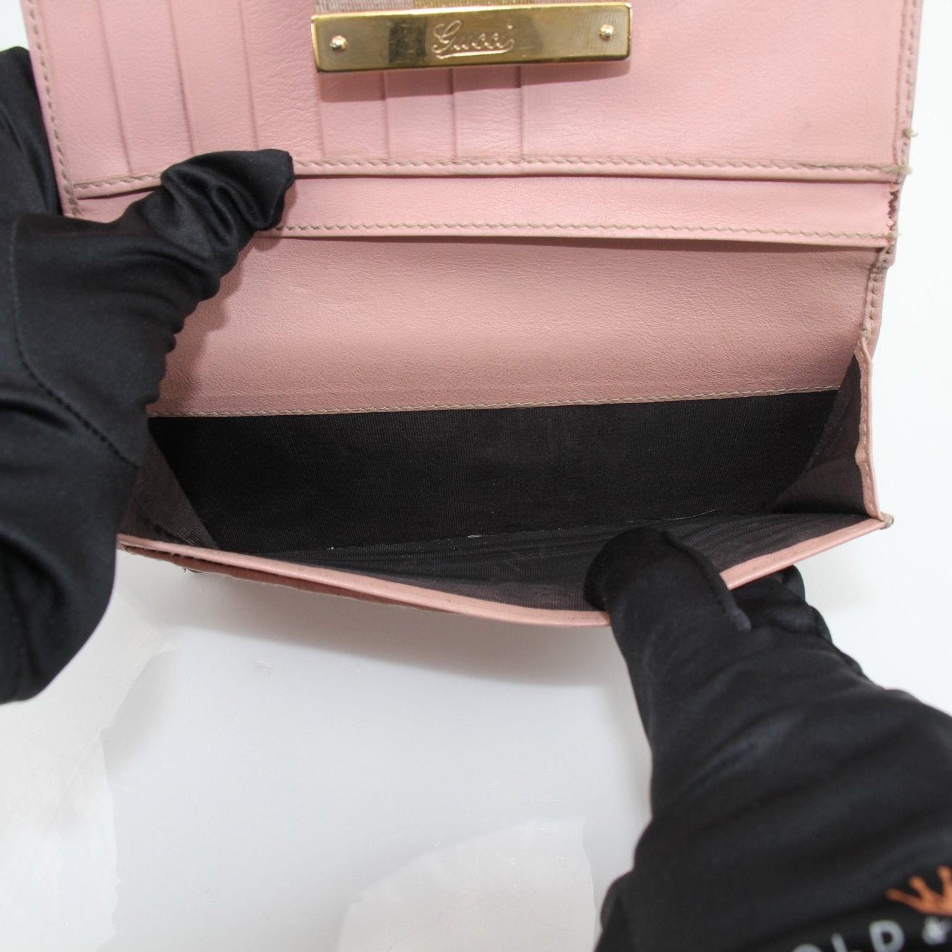 Gucci pink GG continental wallet with gold accents, showcasing the luxurious leather design and signature pattern.