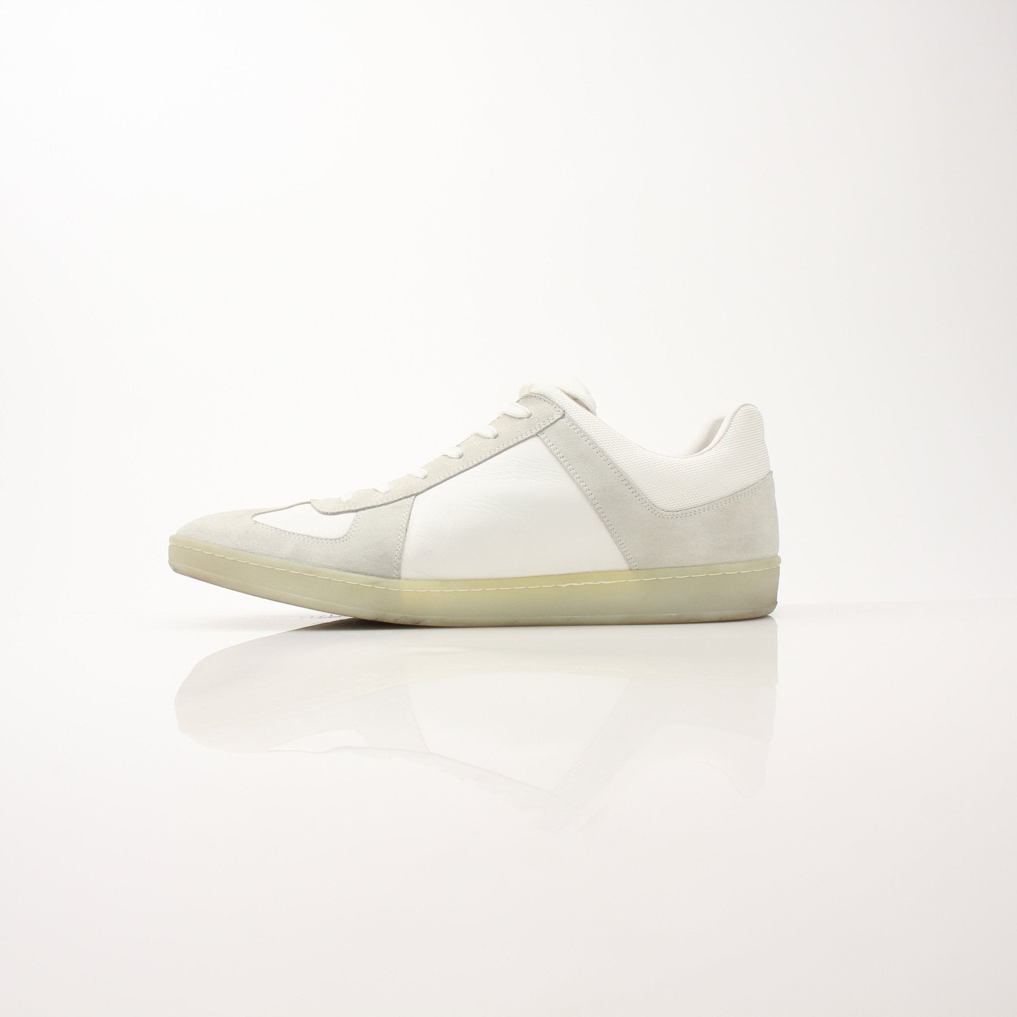 White Louis Vuitton low top sneakers by Gold & Beyond, featuring sleek design and classic branding, displayed on a plain background.