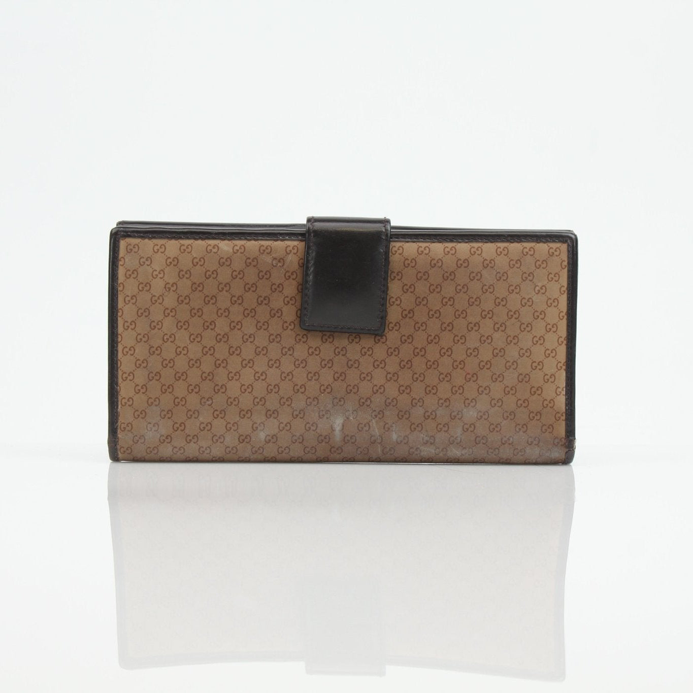 Gucci Guccissima canvas wallet with gold accents, compact design, and signature patterned leather for stylish everyday use.