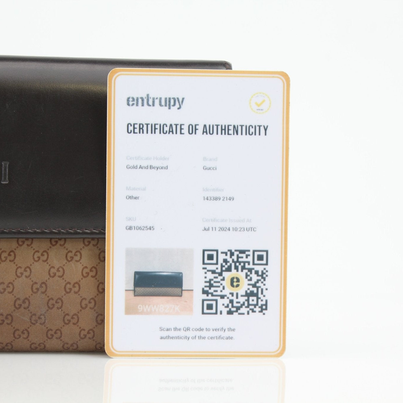 Gucci Guccissima canvas wallet with gold accents, compact design, and branded logo, displayed on a neutral background.