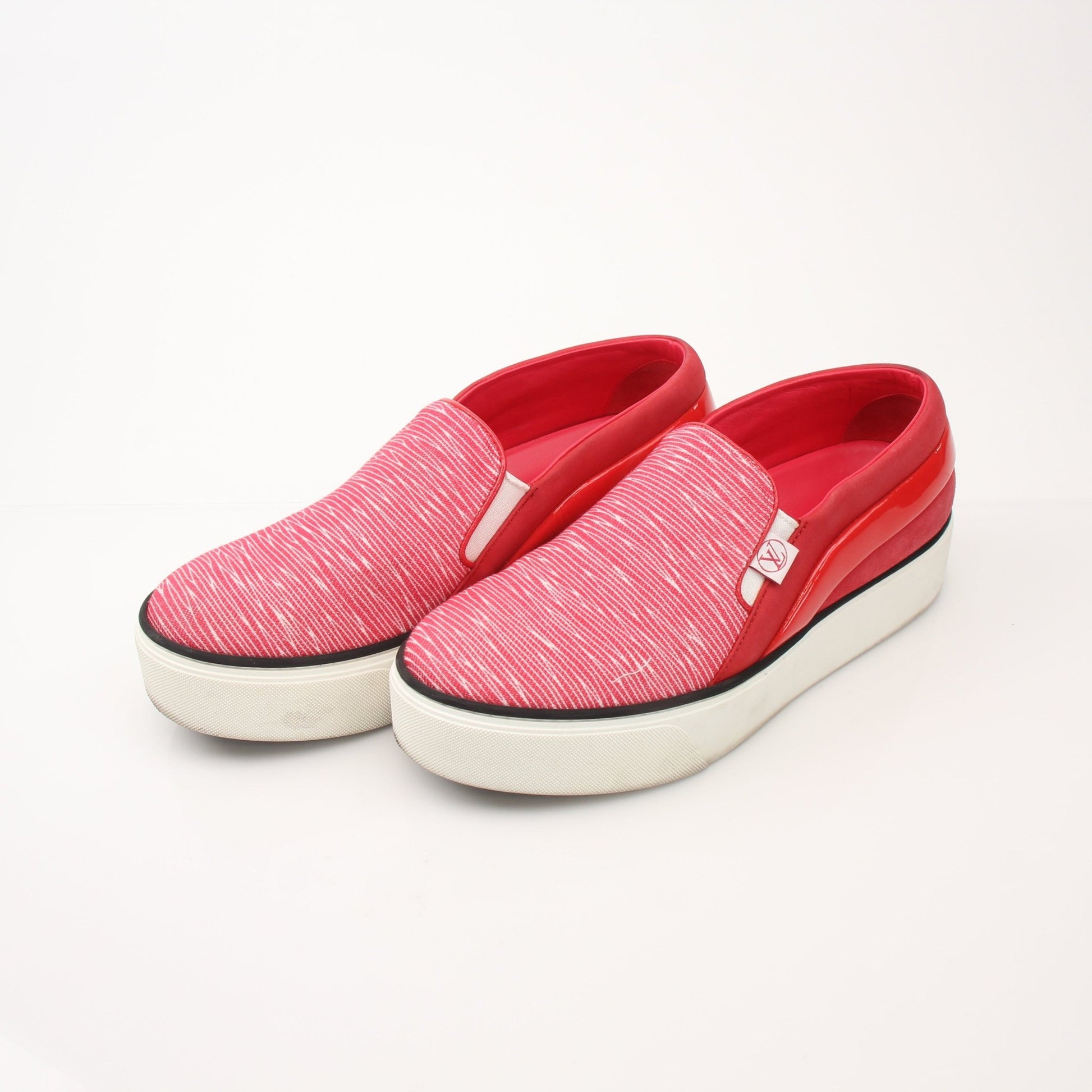 Gold & Beyond Louis Vuitton red slip-on sneakers with sleek design and comfortable fit, displayed on a white background.
