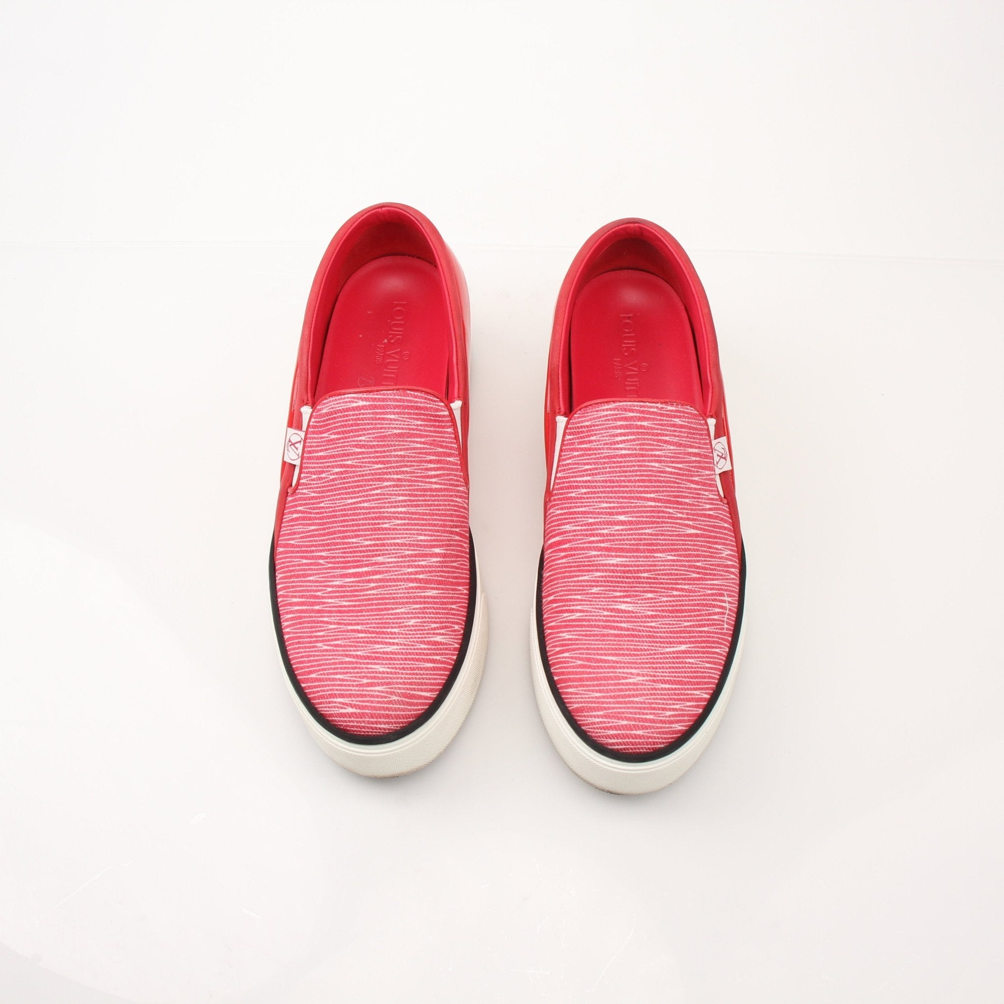 Gold & Beyond red Louis Vuitton slip-on sneakers with sleek design and white rubber soles, displayed on a plain background.