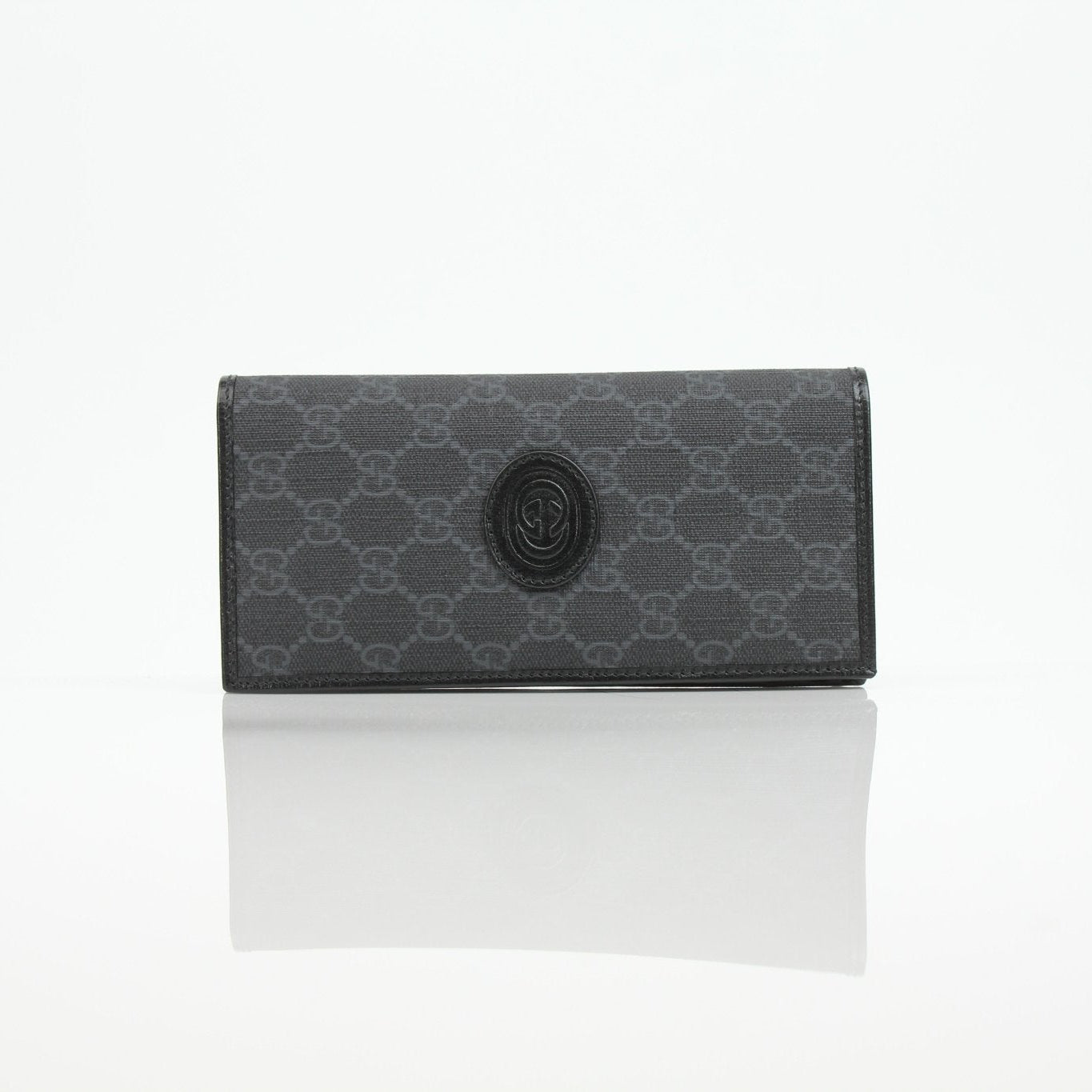 Gucci GG Supreme black wallet with gold accents, featuring the iconic monogram pattern and multiple card slots.