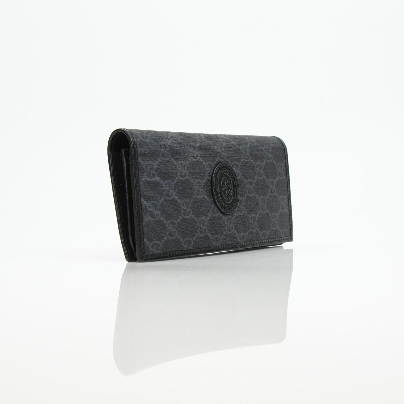 Gucci GG Supreme black wallet with gold accents, featuring a sleek design and multiple card slots, by Gold & Beyond.