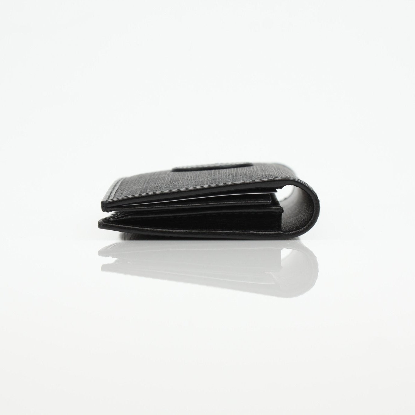 Gucci GG Supreme black wallet with gold accents, featuring a sleek design and multiple card slots.